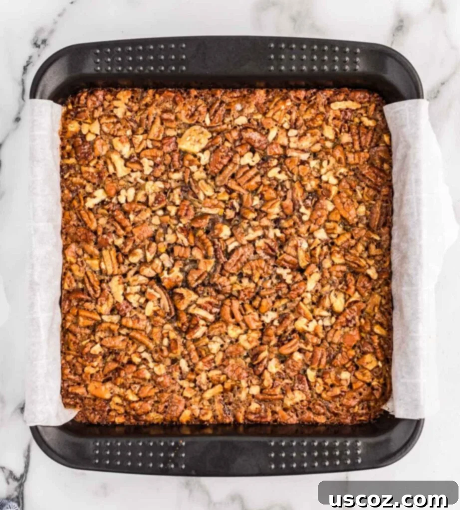 Decadent Pecan Pie Bars 7 pecan pie bar filling being poured over the baked shortbread crust