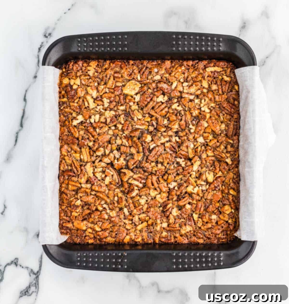 Decadent Pecan Pie Bars 8 pecan pie bars baking in an 8x8 baking dish