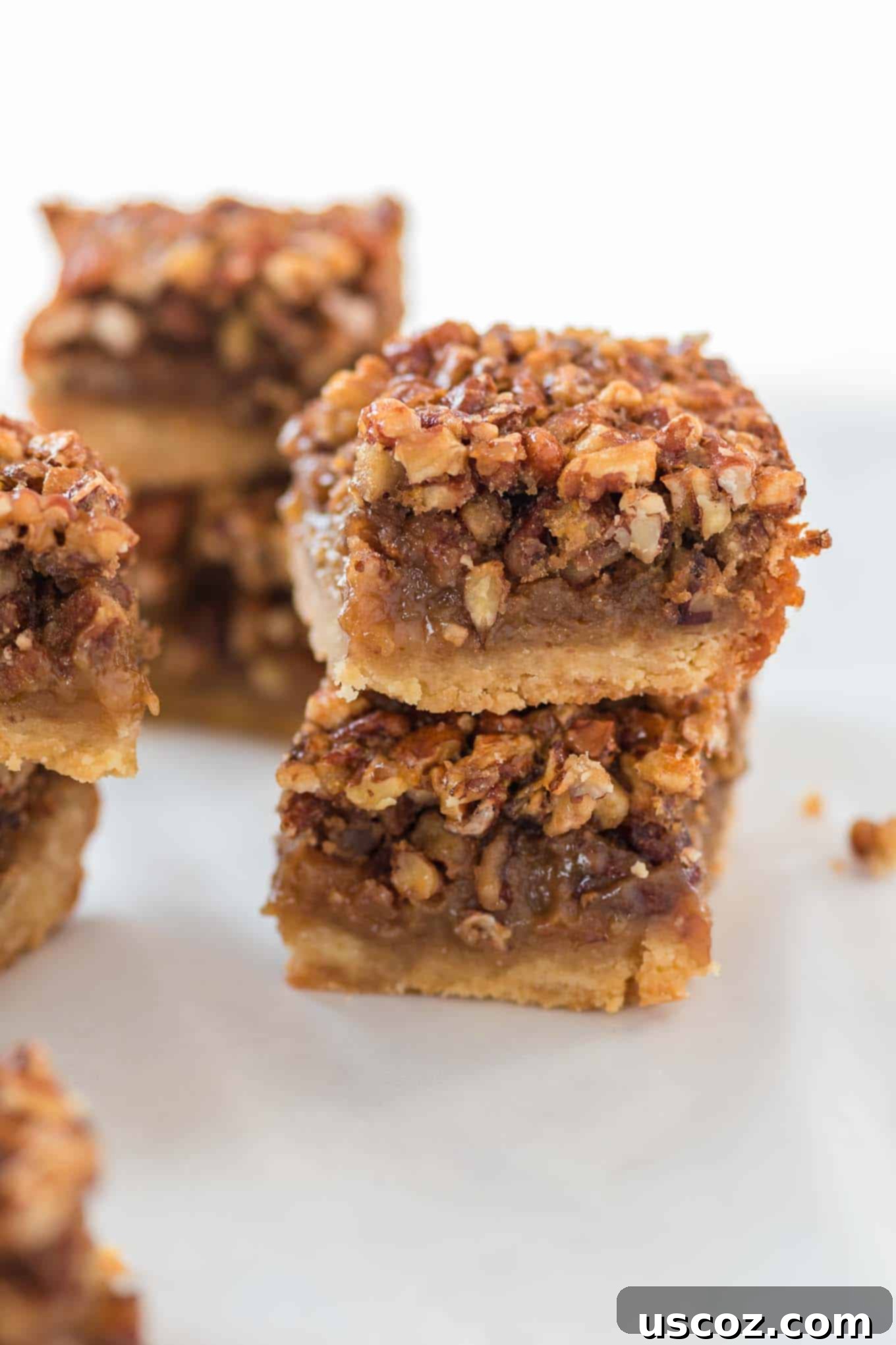 Decadent Pecan Pie Bars 10 two pecan pie bars stacked on a serving plate