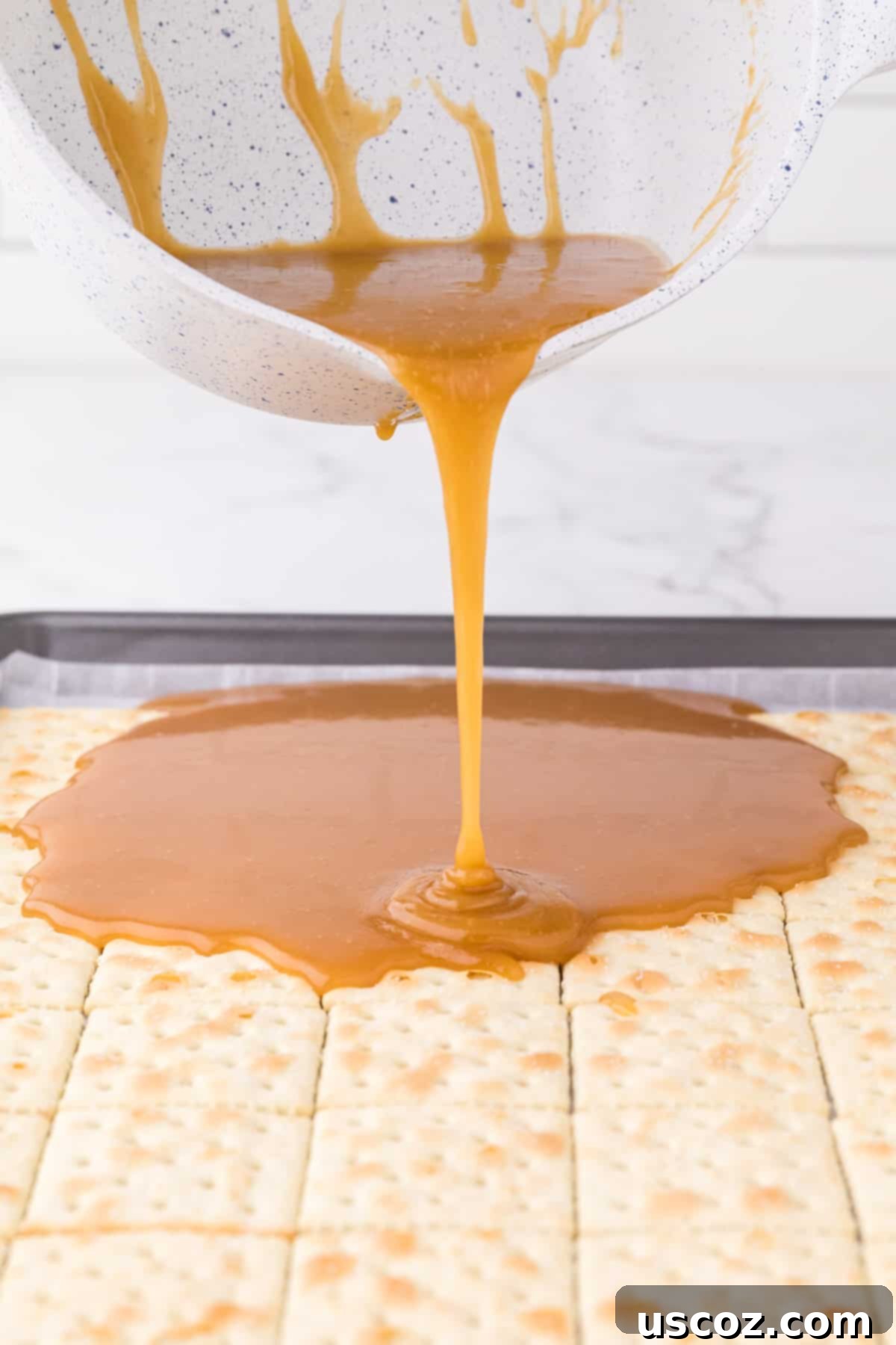 Christmas Cracker Toffee Recipe 9 pouring the toffee layer over the saltines
