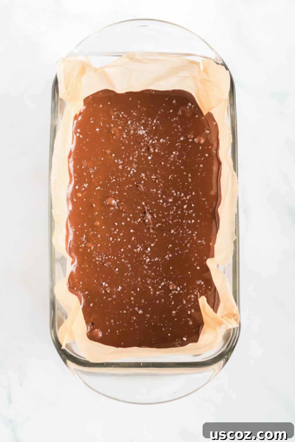 Decadent Vegan Chocolate Peanut Butter Fudge 6 Fudge batter being poured into a loaf pan lined with wax paper, ready for chilling.