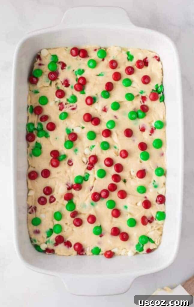 Merry Cookie Bar Magic 12 topping the cookie bar batter with more red and green M&M's before baking