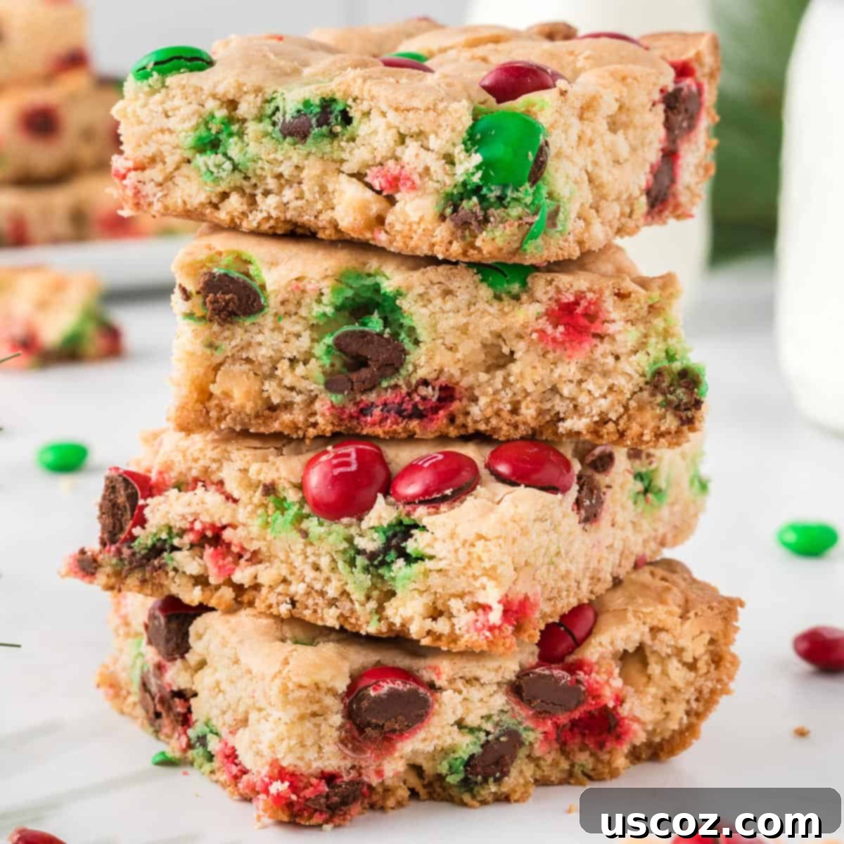 Merry Cookie Bar Magic 14 Christmas cookie bars stacked on top of each other, showcasing their thickness and M&M's