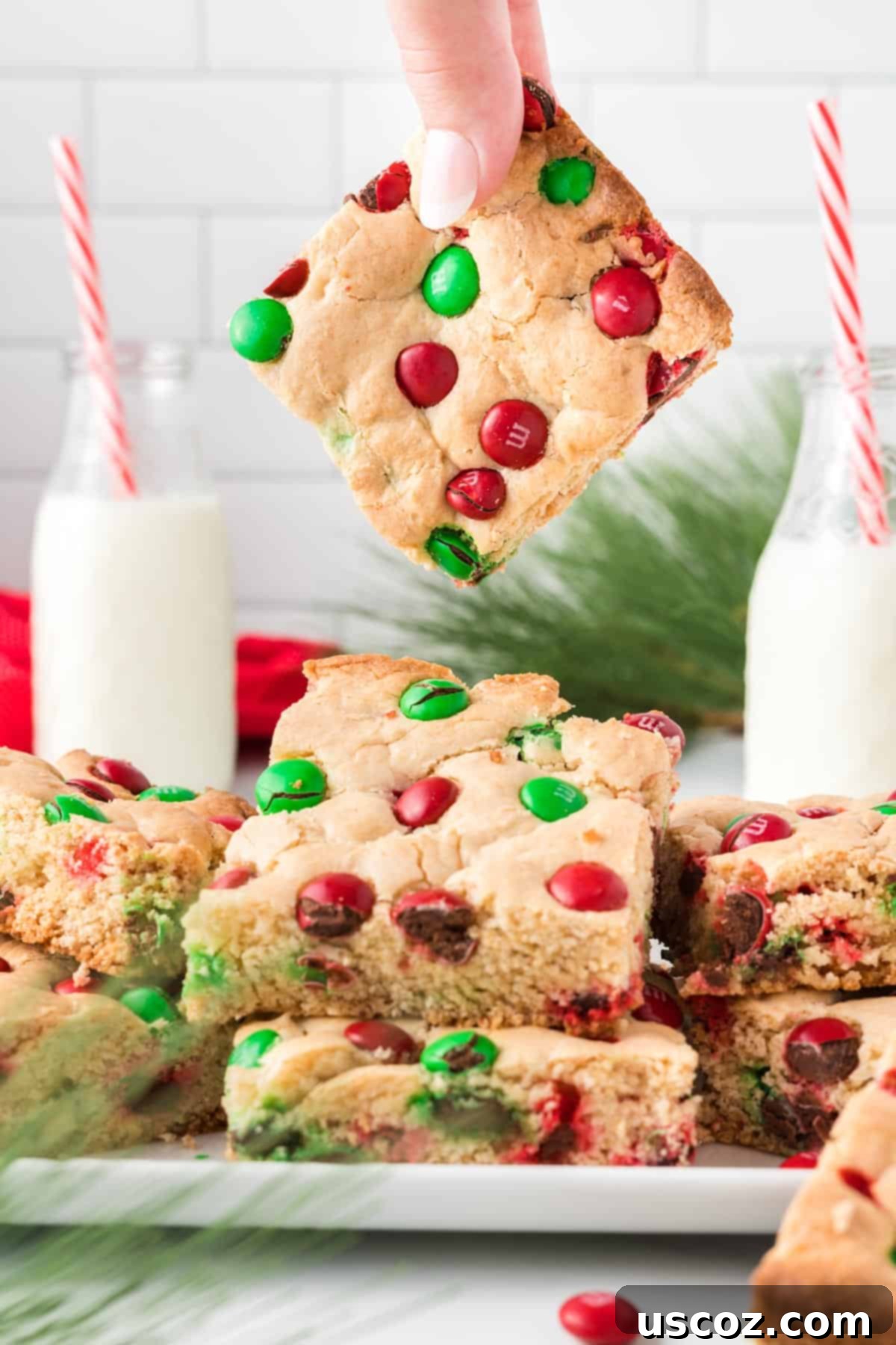 Merry Cookie Bar Magic 16 a hand holding a single Christmas cookie bar above the baking dish