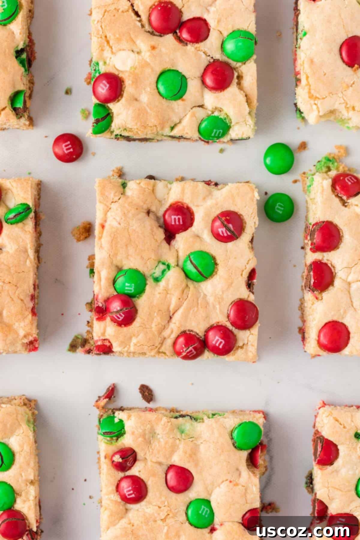 Merry Cookie Bar Magic 3 Christmas cookie bars with red and green M&M's, cut into squares and served on a wooden board