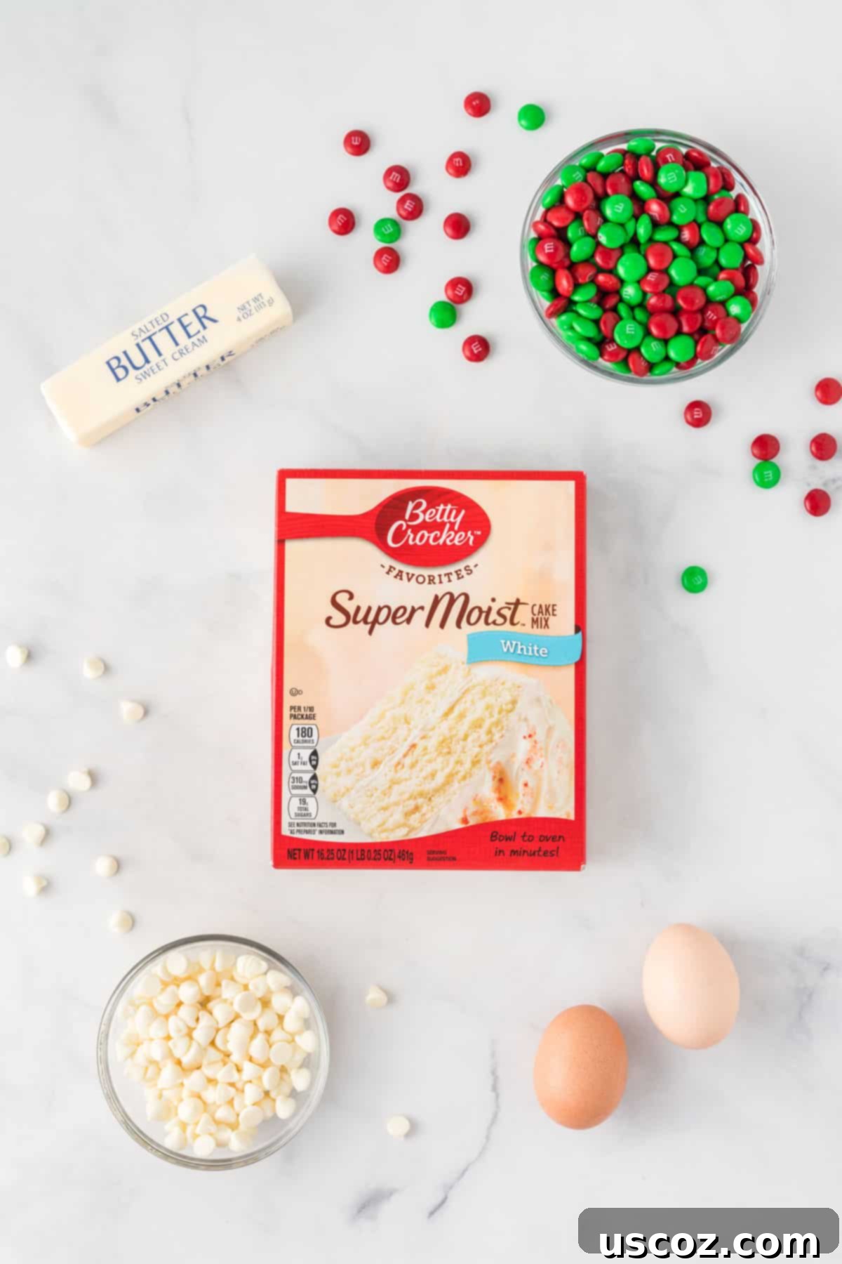 Merry Cookie Bar Magic 4 ingredients needed to make cake mix Christmas cookie bars including cake mix, butter, eggs, M&M's, and white chocolate chips