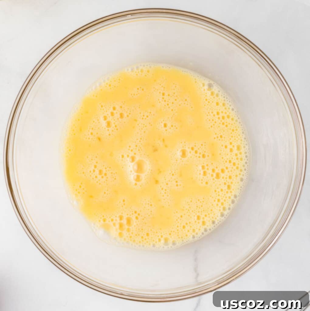 Merry Cookie Bar Magic 6 whisked eggs in a mixing bowl, ready for other ingredients