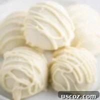 Decadent White Chocolate Peanut Butter Bliss Balls 12 white chocolate balls stacked on a white plate