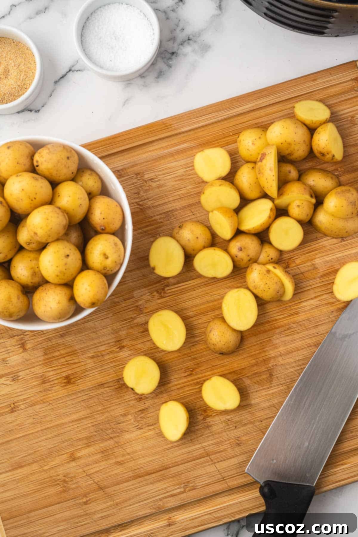 Crispy Golden Air Fryer Baby Potatoes 5 baby potatoes cut in half on a cutting board