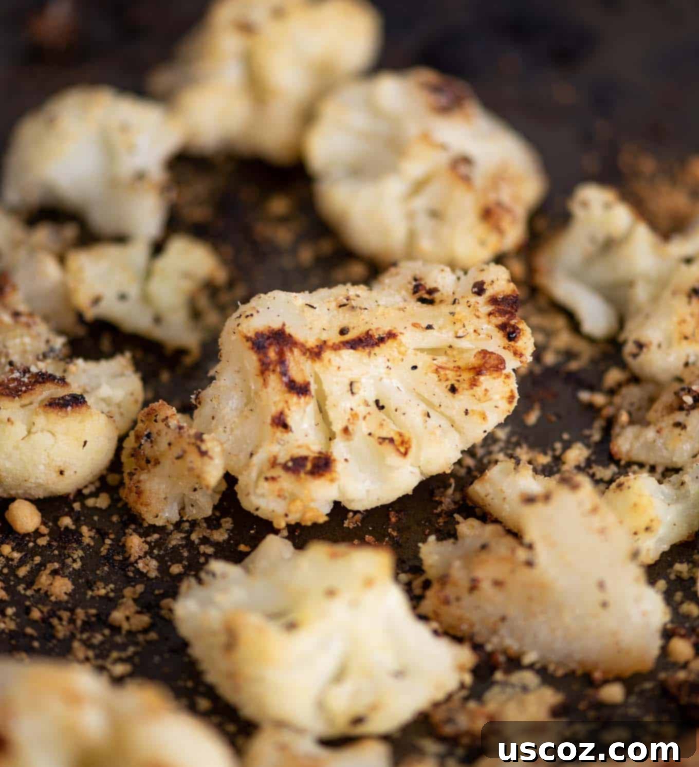 Crispy Roasted Frozen Cauliflower 5 Close-up of golden-brown roasted cauliflower on a baking sheet after the first roasting phase