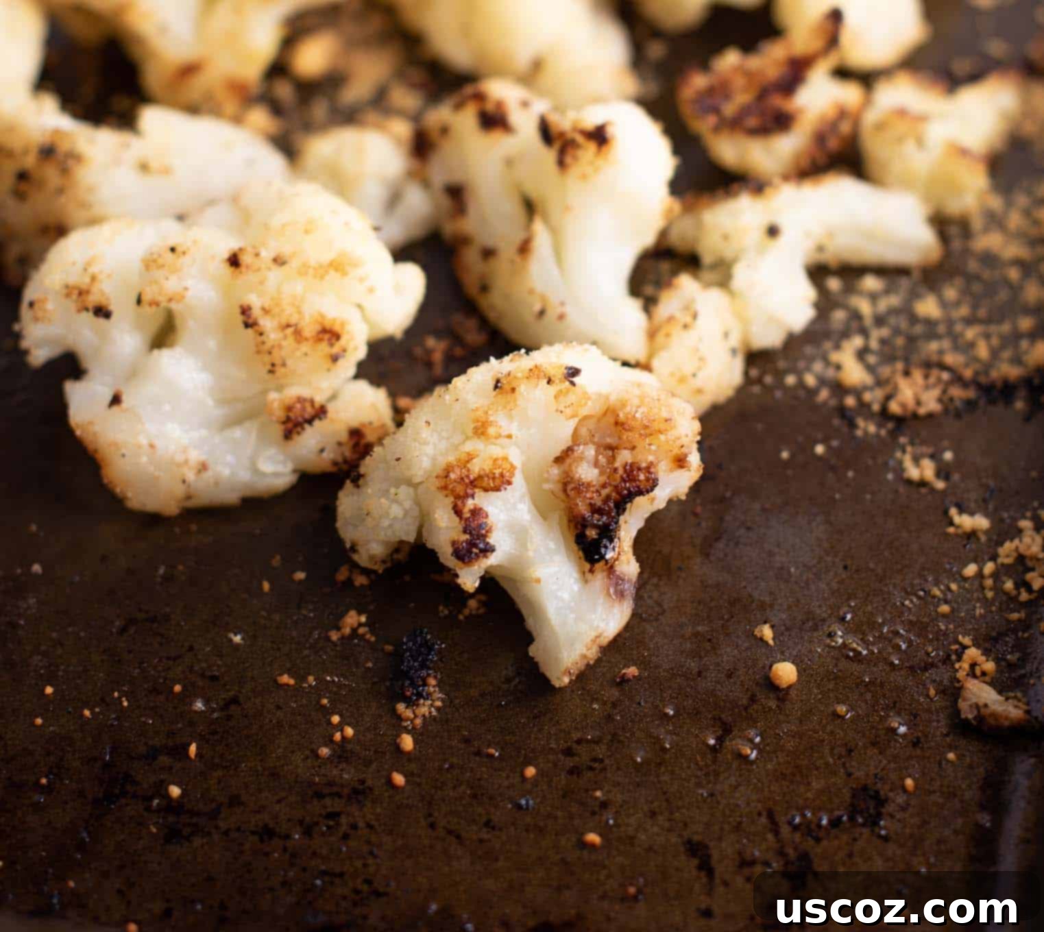 Crispy Roasted Frozen Cauliflower 6 Finished roasted frozen cauliflower, golden and crispy, ready to be served from a brown baking sheet