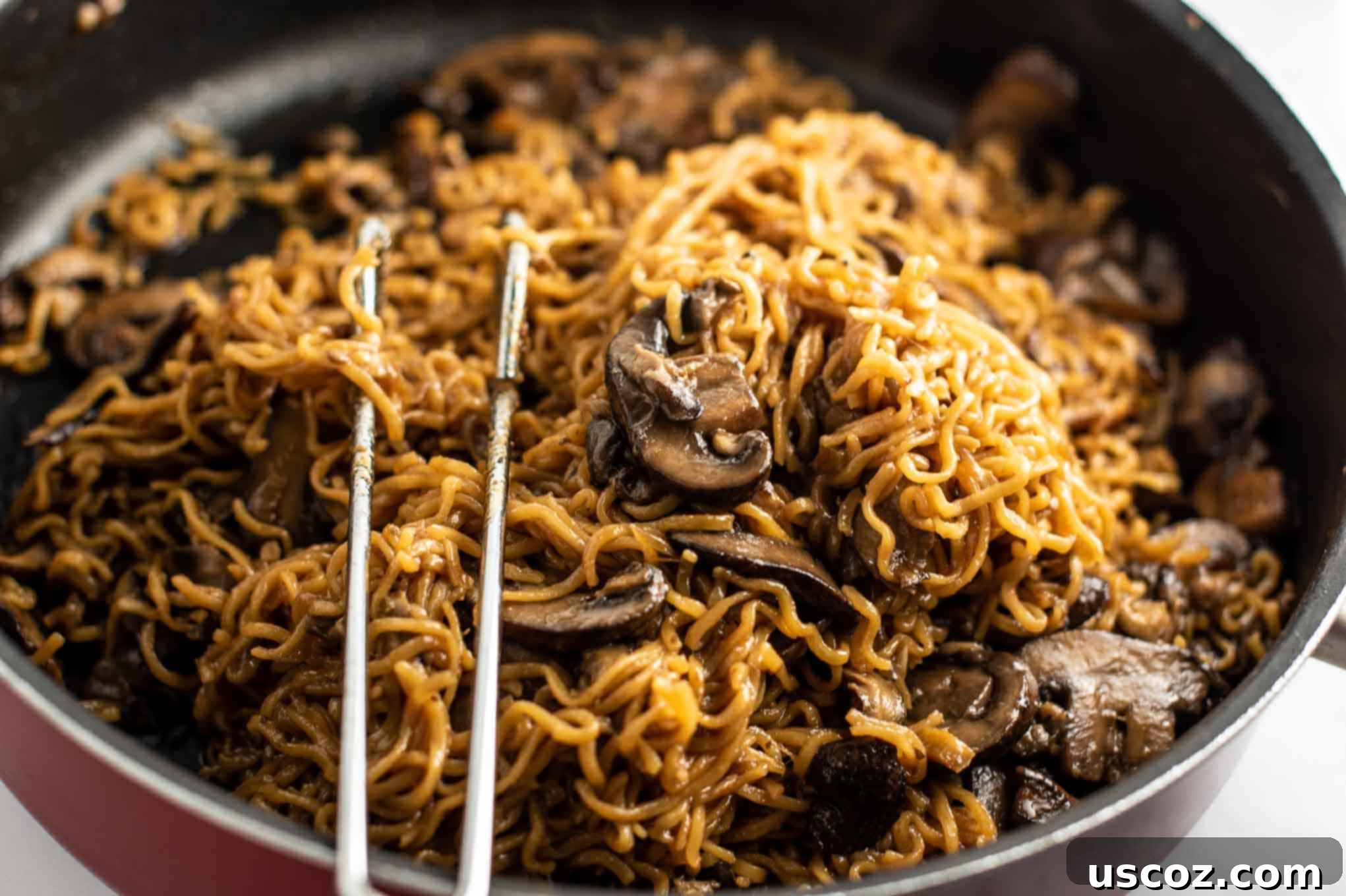 Umami Mushroom Ramen 11 A vibrant red jumbo cooker pan full of savory ramen noodles with mushrooms, steaming gently.