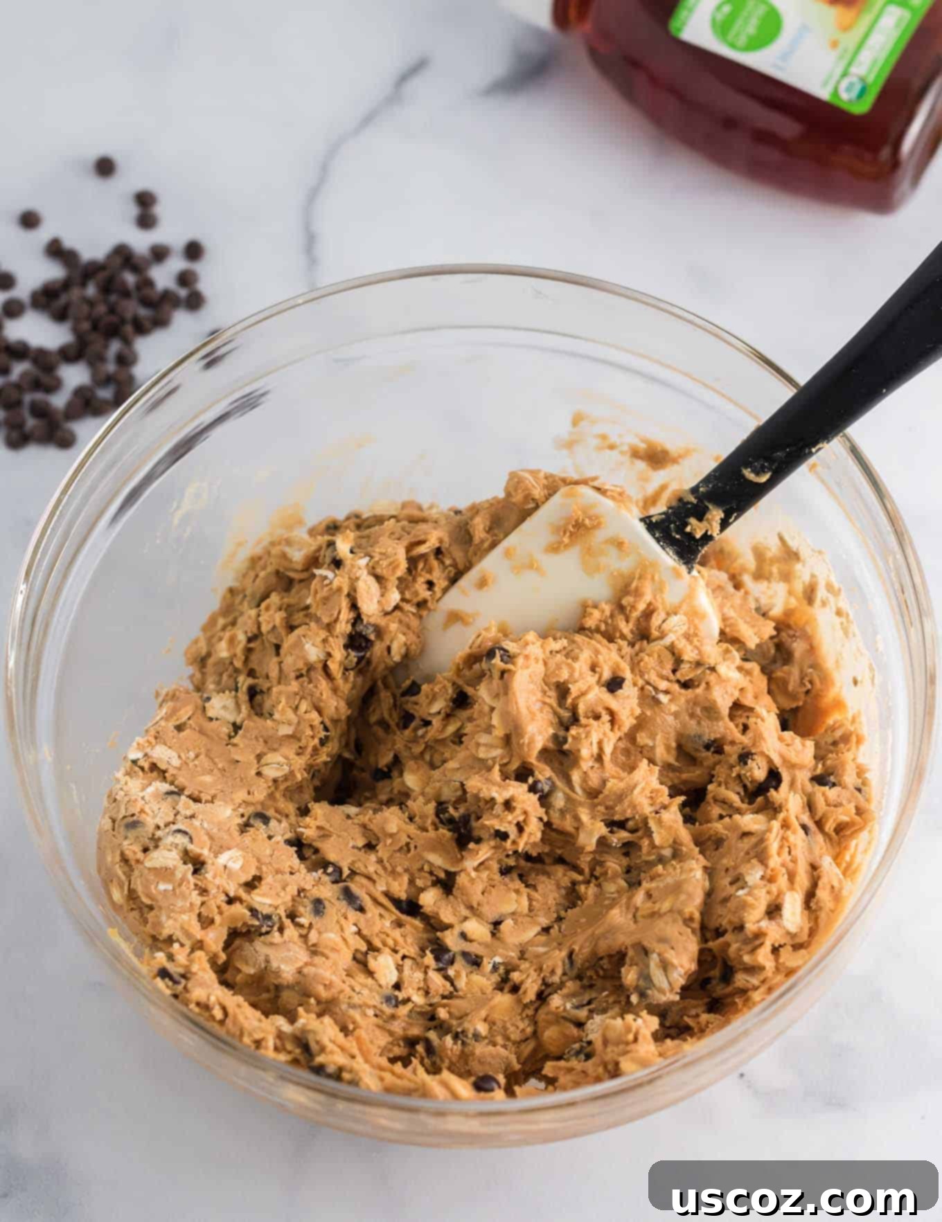 Wholesome Energy Bites 6 The energy ball ingredients thoroughly mixed together in a bowl with a rubber spatula, forming a thick, uniform batter