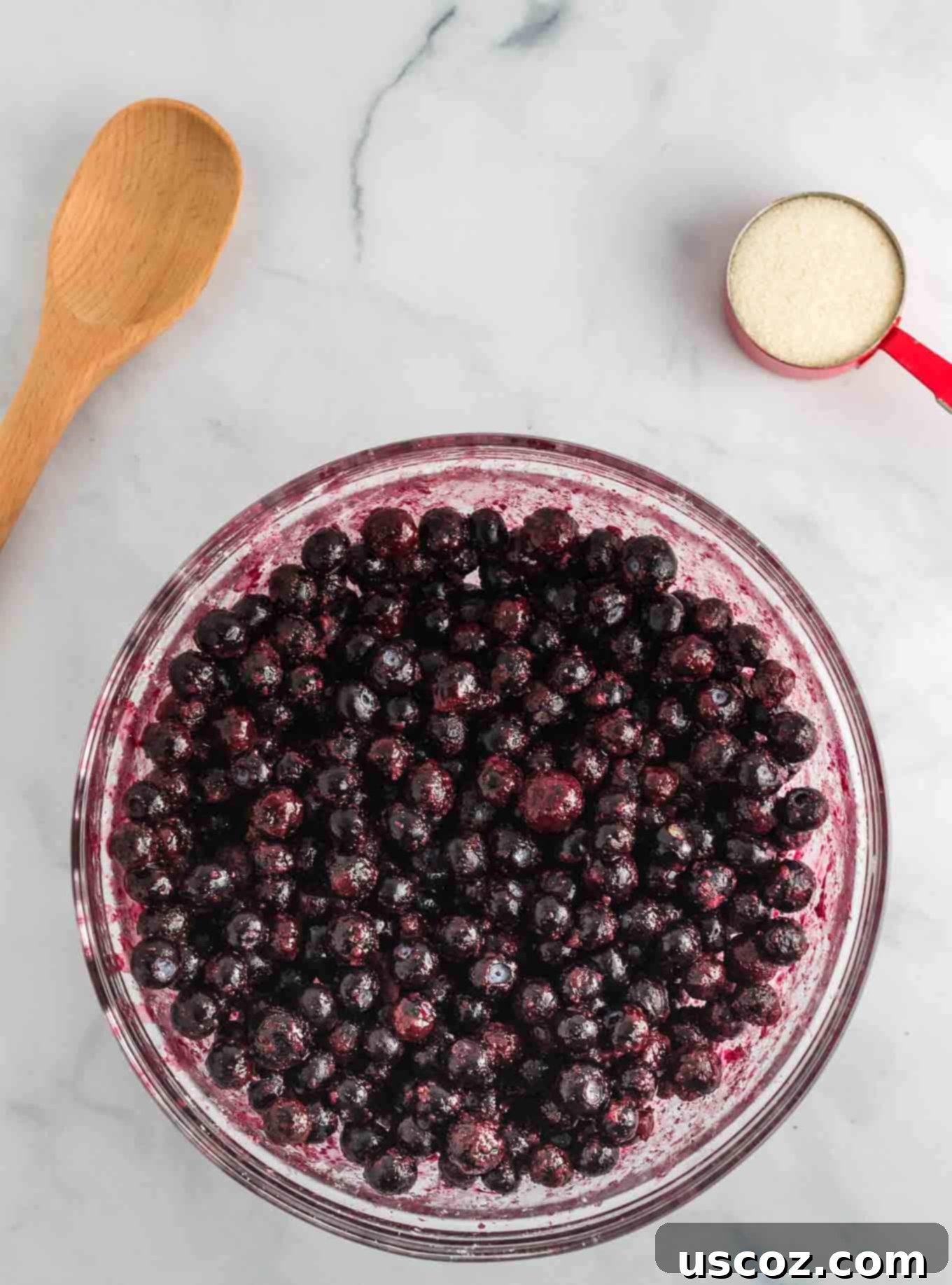 Warm Blueberry Crisp Delight 6 Close-up of frozen blueberries in a clear bowl after sitting for a few minutes, showing some melted areas.