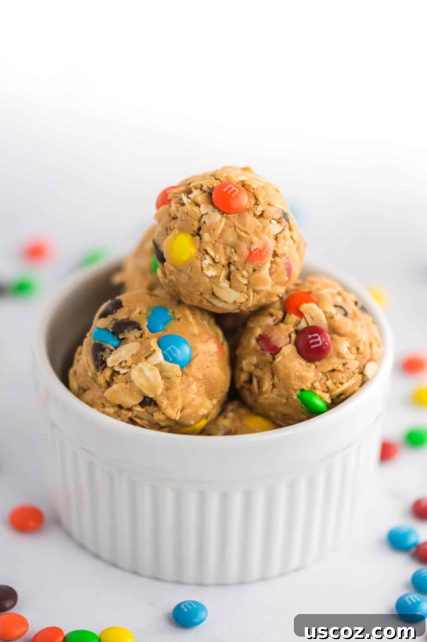 Monster Cookie Energy Bites 2 Monster Cookie Energy Balls with vibrant mini M&M's and chocolate chips visible on the sides, perfectly rounded and inviting.