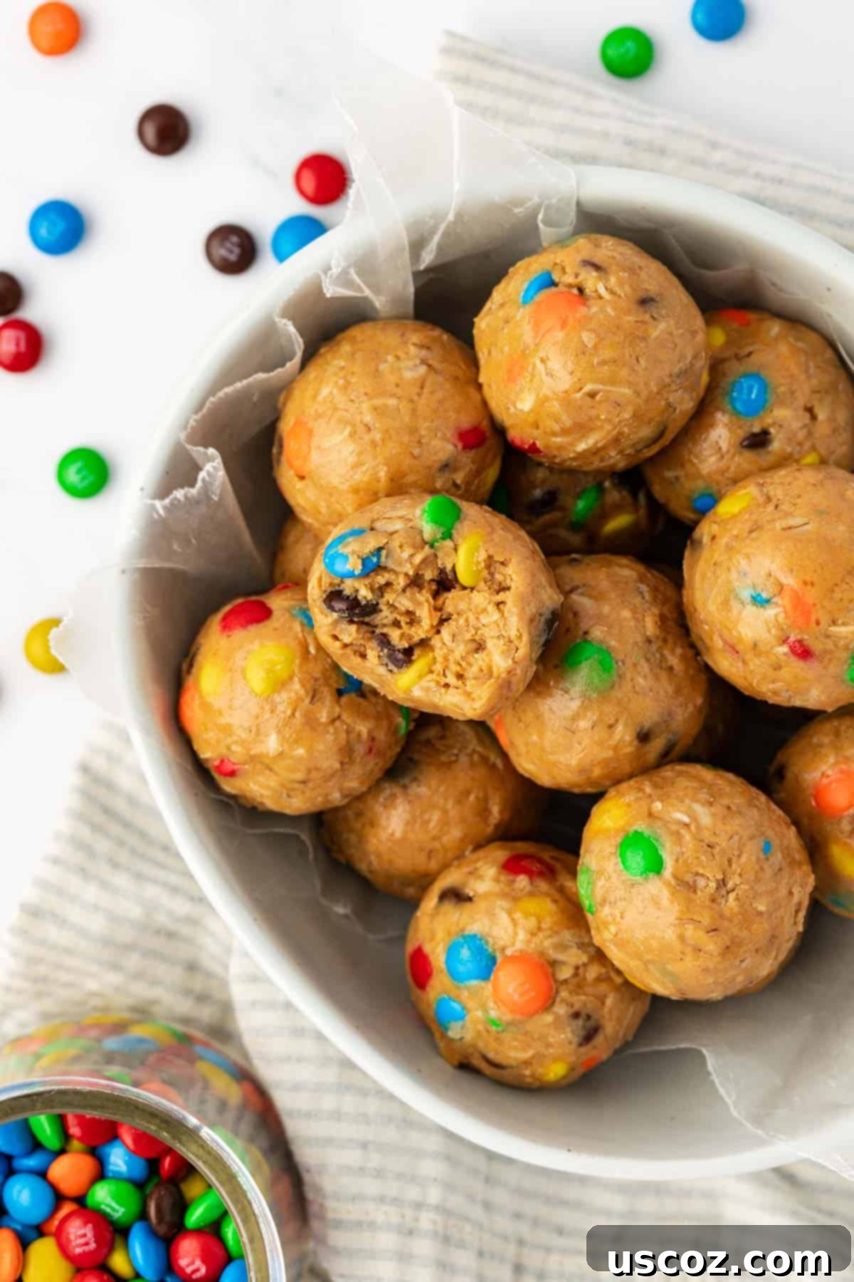 Monster Cookie Energy Bites 11 A close-up of a single monster cookie bite held delicately, highlighting its inviting texture and toppings.