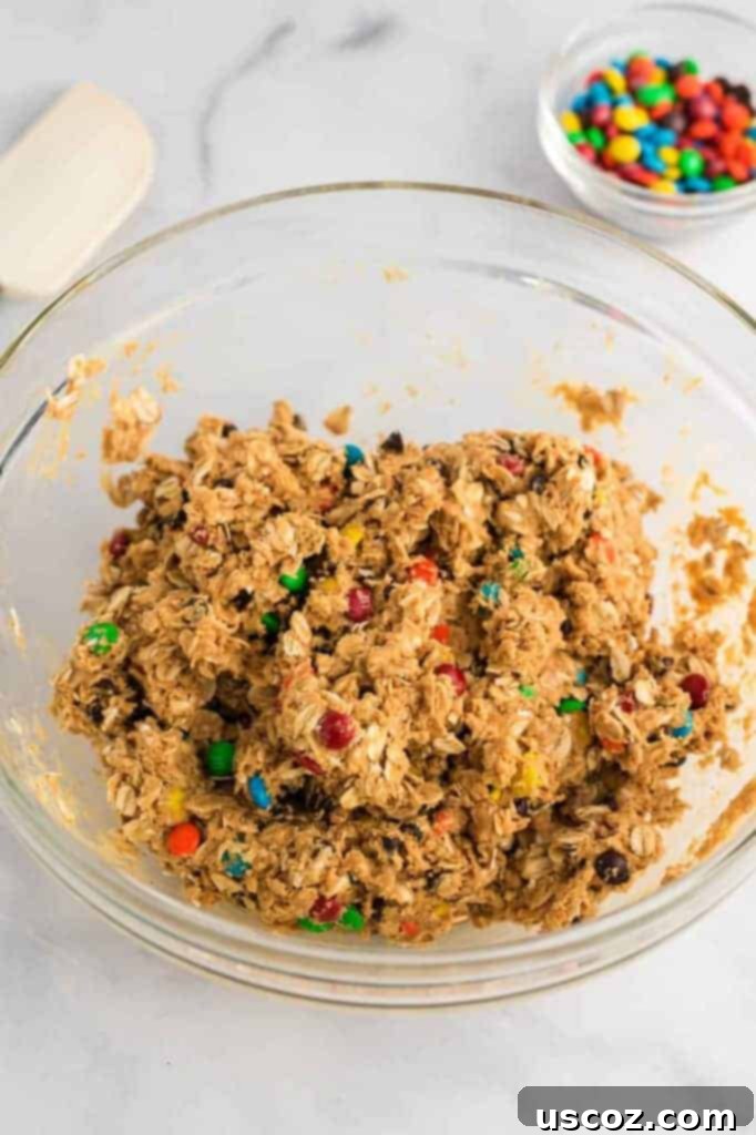Monster Cookie Energy Bites 7 The fully mixed energy ball batter resembling chunky cookie dough, studded with oats, chocolate chips, and M&M's, ready for rolling.