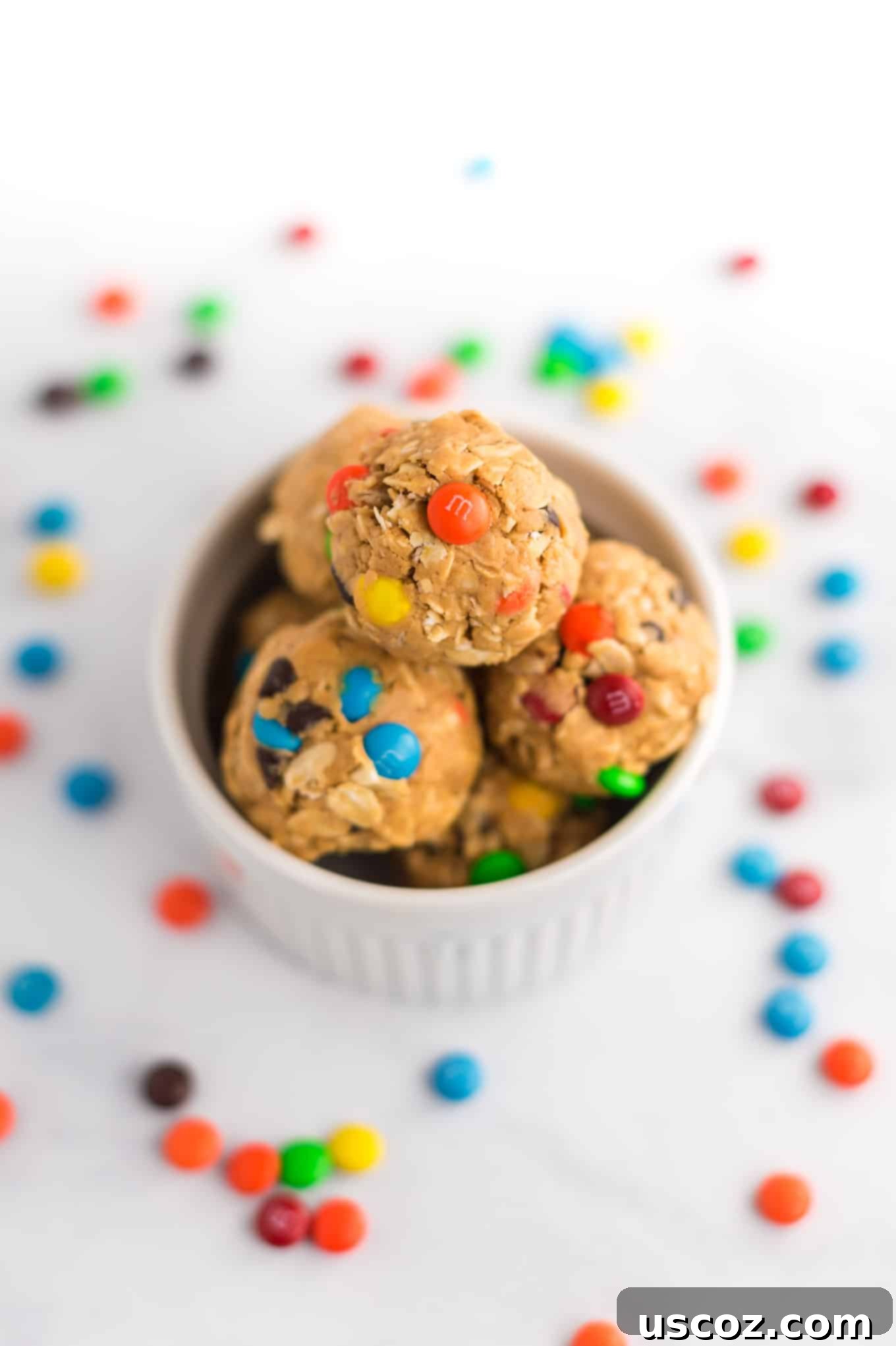 Monster Cookie Energy Bites 9 A stack of perfectly formed and chilled monster cookie energy balls nestled in a white ramekin, ready to be enjoyed.