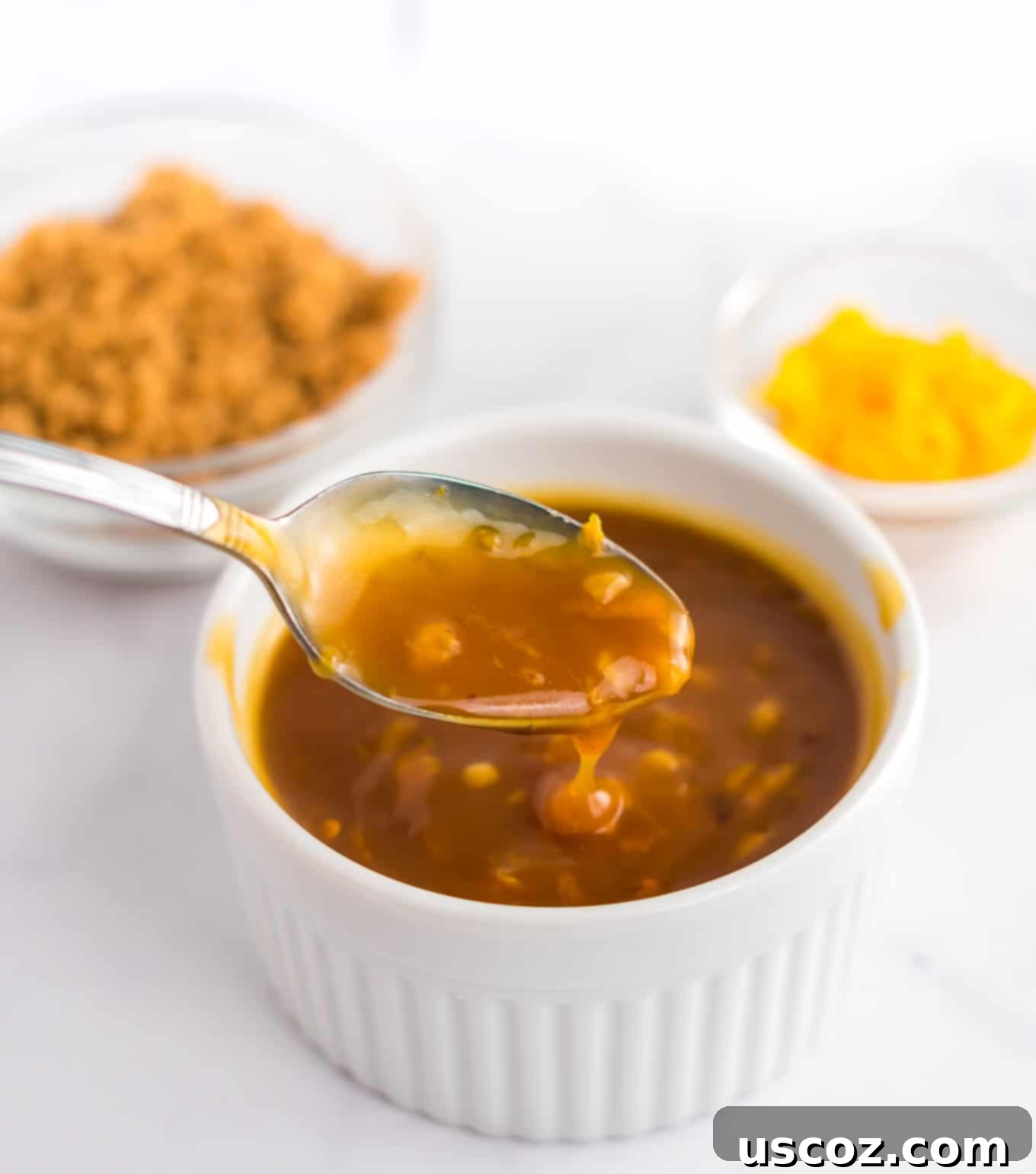 Zesty Orange Sauce 9 a spoon dipping into orange sauce