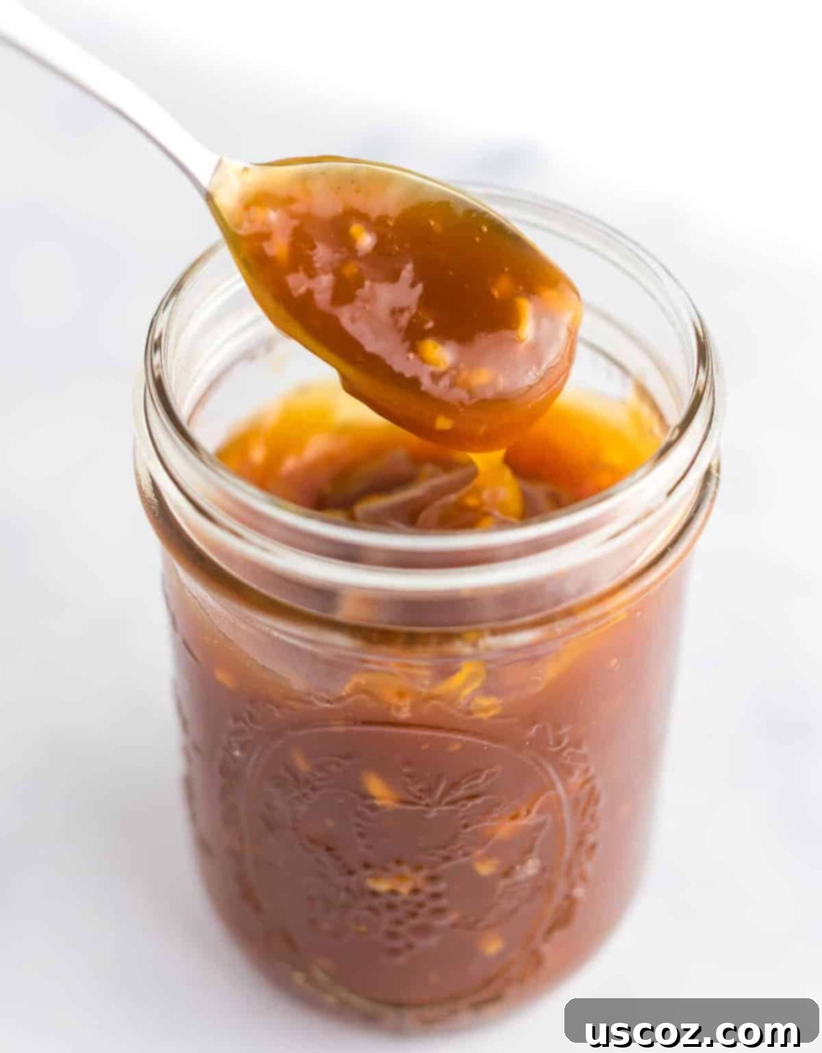 Zesty Orange Tofu 11 a spoon taking a dip of orange sauce for orange tofu or orange chicken