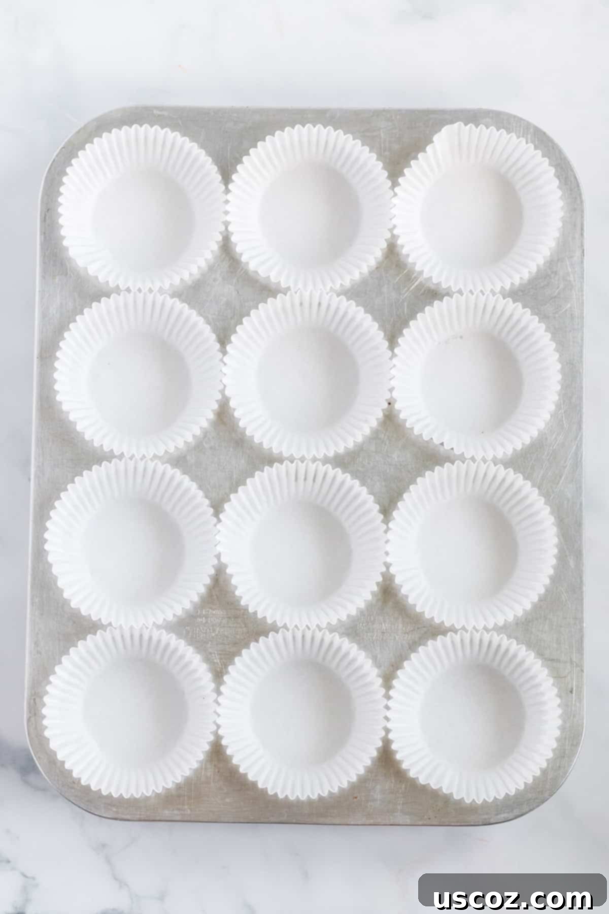 Plant-Based Peanut Butter Perfection 5 muffin tin lined with white muffin liners