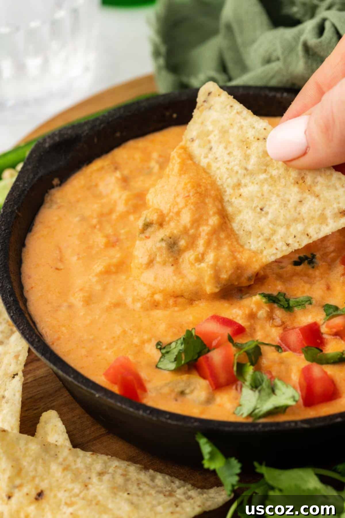 Easy Crock Pot Queso Dip 8 tortilla chip being dipped into queso