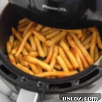 Perfectly Crispy Air Fryer Frozen Fries 8 A bowl of crispy air fryer french fries, garnished with fresh herbs, ready to be served.