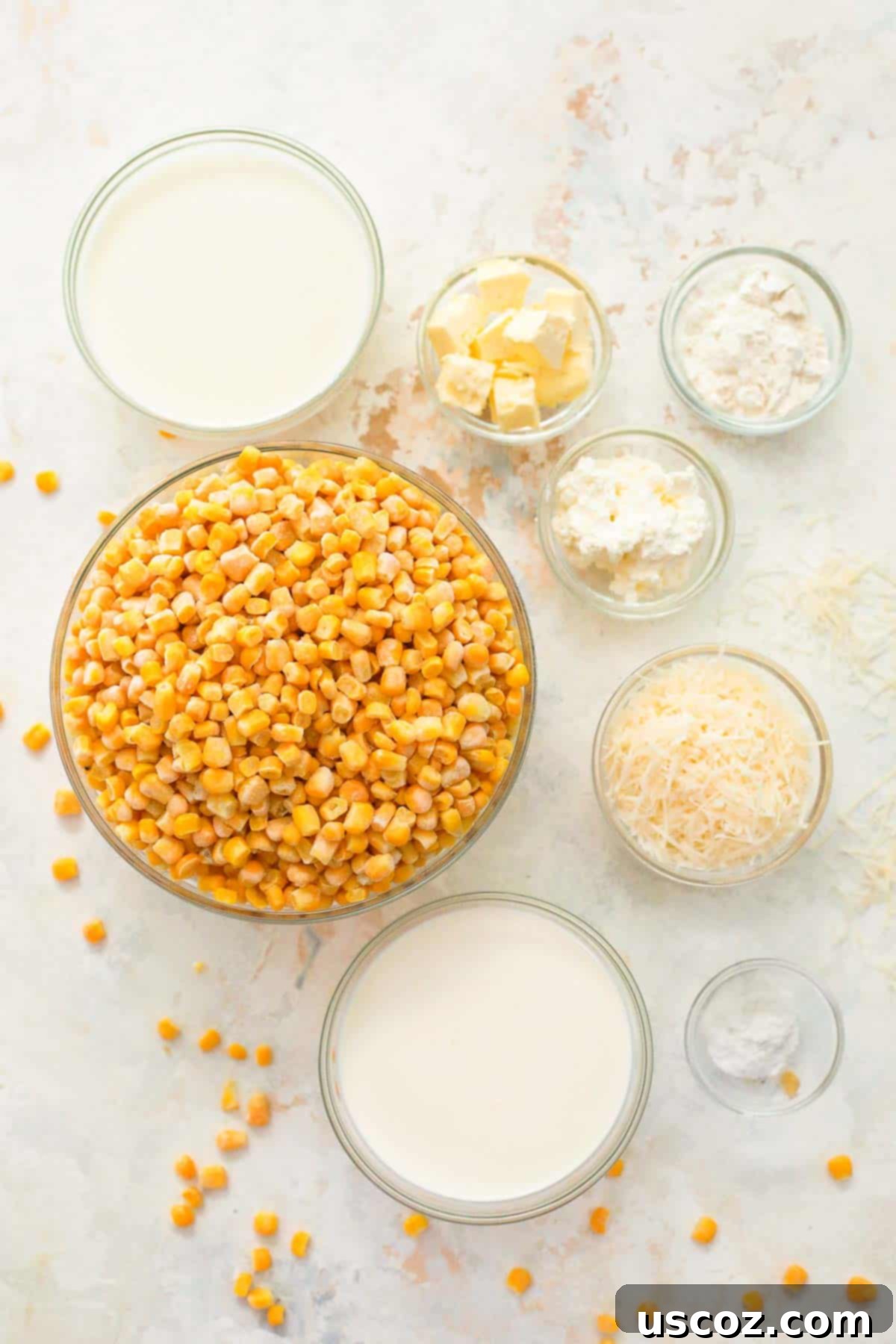 Dreamy Creamed Corn 3 Glass bowls filled with the ingredients needed to make creamed corn, including frozen corn kernels, heavy cream, milk, butter, cheeses, and spices, all neatly arranged.
