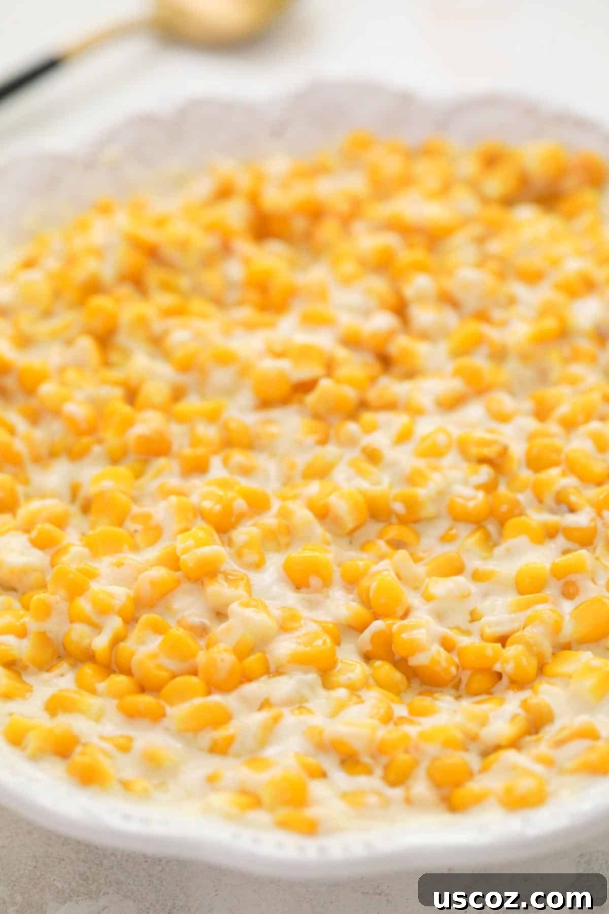 Dreamy Creamed Corn 5 A white serving dish filled with perfectly cooked, creamy creamed corn, ready to be enjoyed as a comforting side dish.