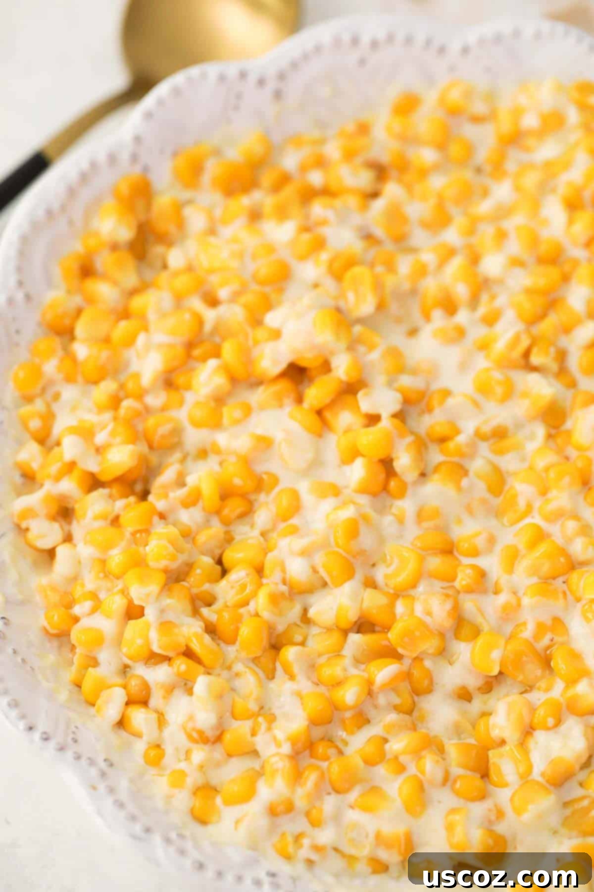 Dreamy Creamed Corn 7 Creamed corn with cream cheese served in a beautiful white serving dish, garnished and ready to be enjoyed as a gourmet side.