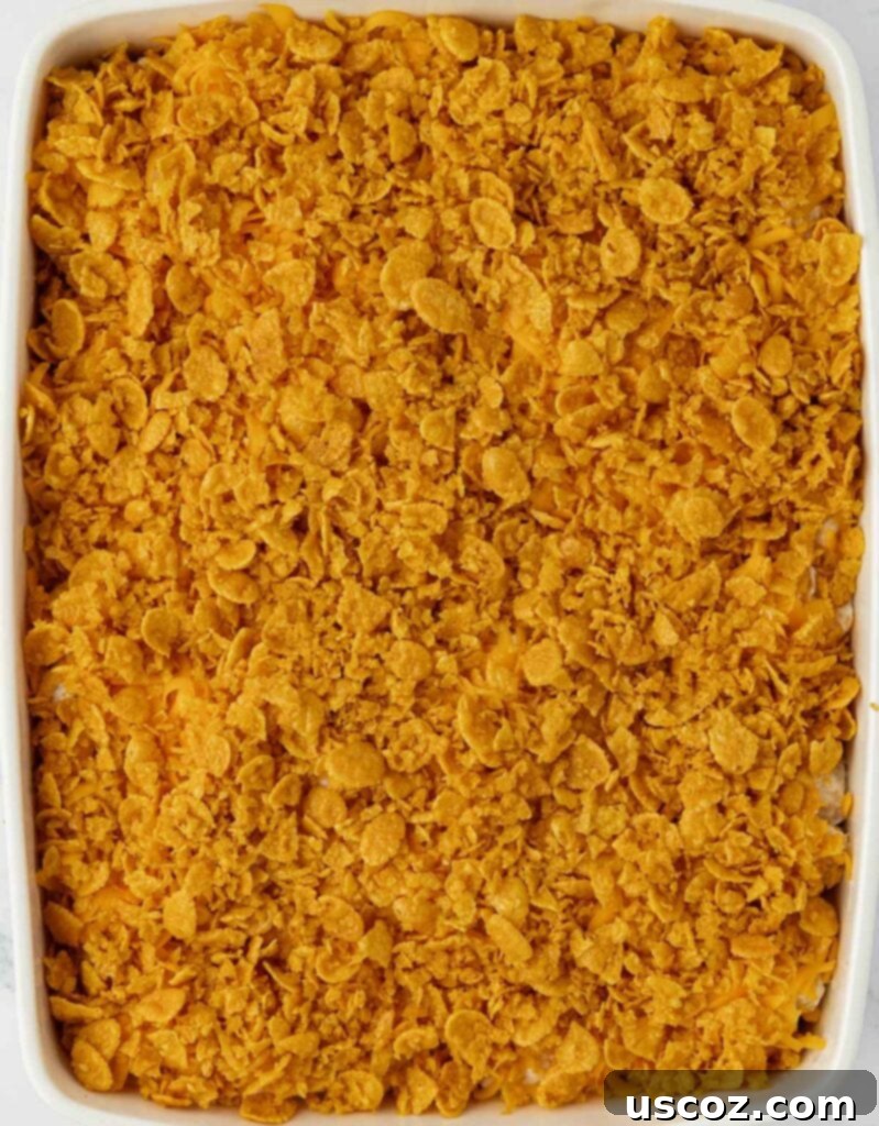 Crispy Cheesy Potato Casserole 14 The unbaked cheesy potato casserole covered with a generous, even layer of buttery corn flake topping, ready for the oven.
