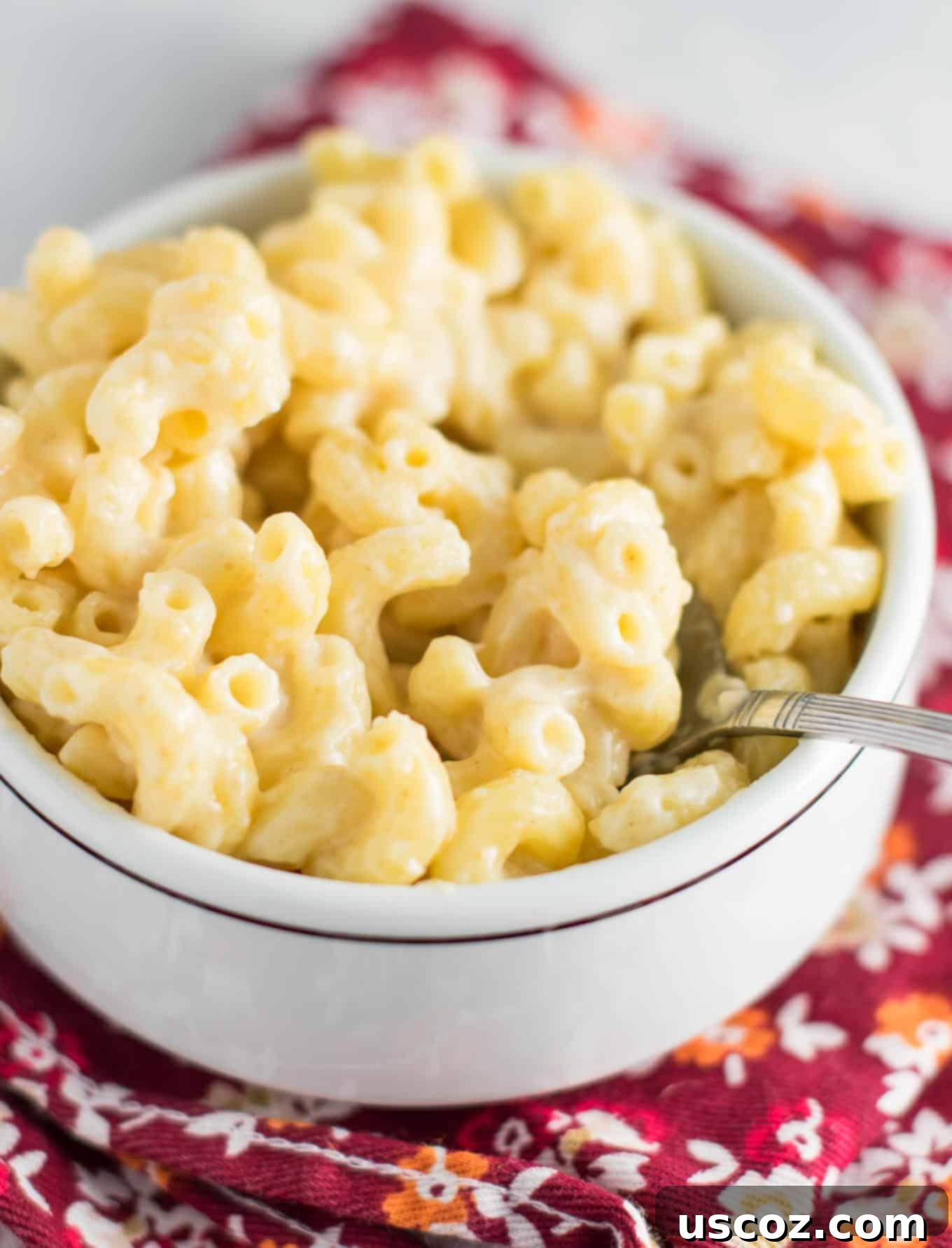Robust Sharp Cheddar Mac and Cheese 5 creamy stove top mac and cheese being stirred in a pot