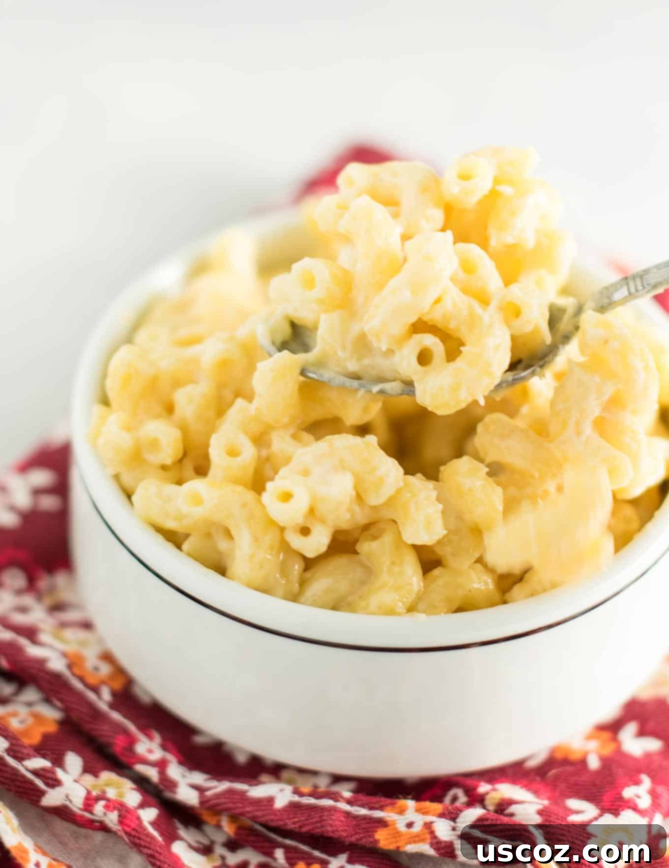 Robust Sharp Cheddar Mac and Cheese 6 child's hands holding a spoon with creamy sharp cheddar mac and cheese