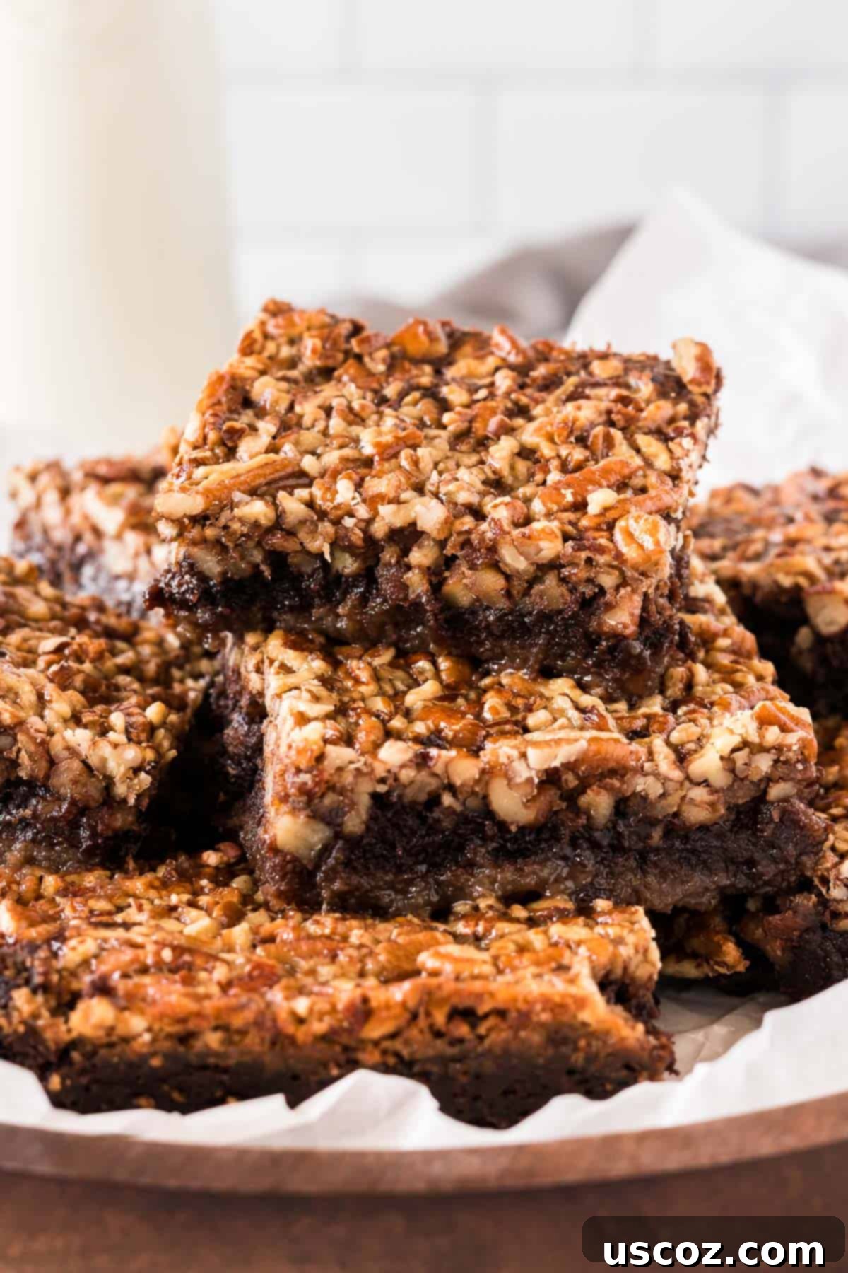 Ultimate Pecan Pie Brownies 2 pecan pie brownies cut into squares and stacked on a plate