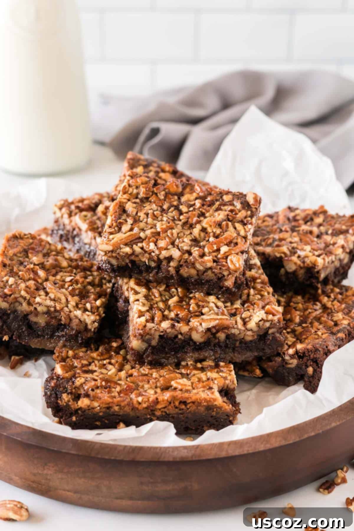 Ultimate Pecan Pie Brownies 14 pecan pie brownies cut into squares and stacked on a plate