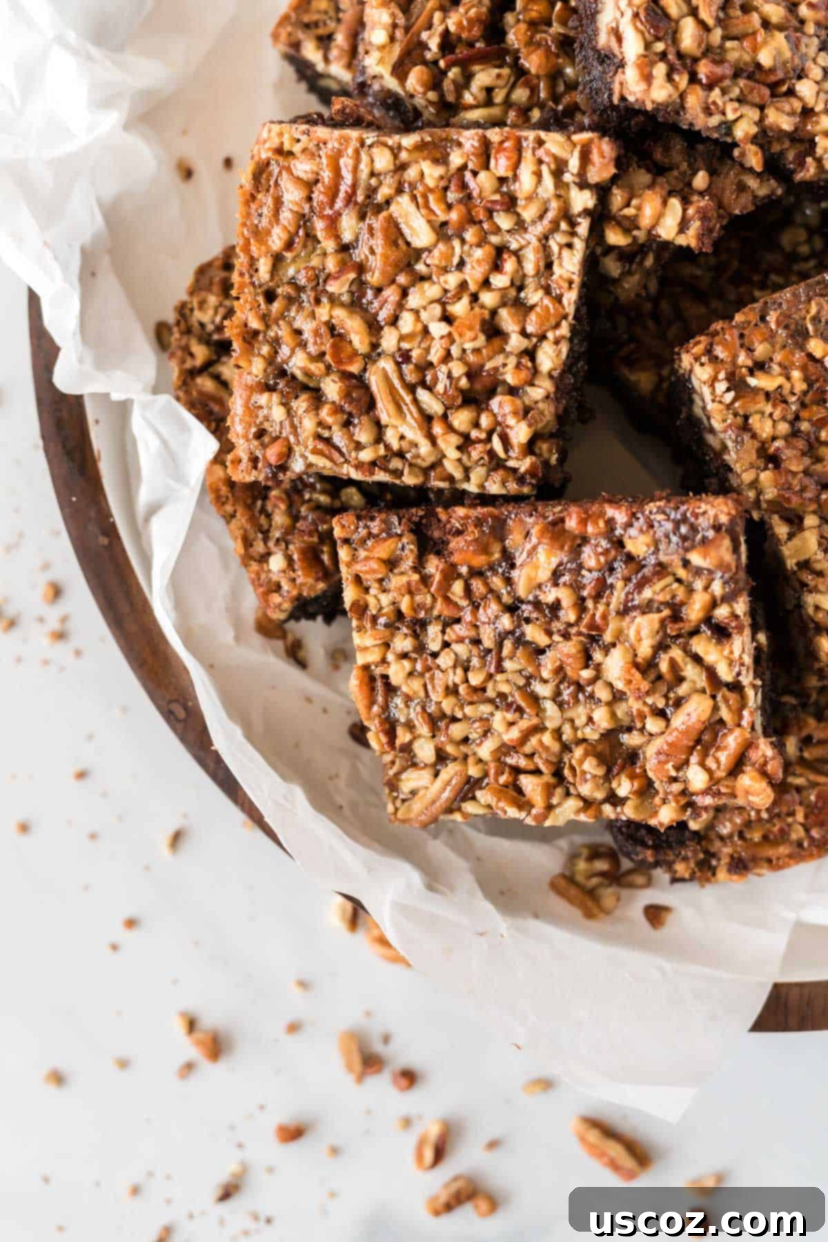 Ultimate Pecan Pie Brownies 15 pecan pie brownies cut into squares and stacked on a plate
