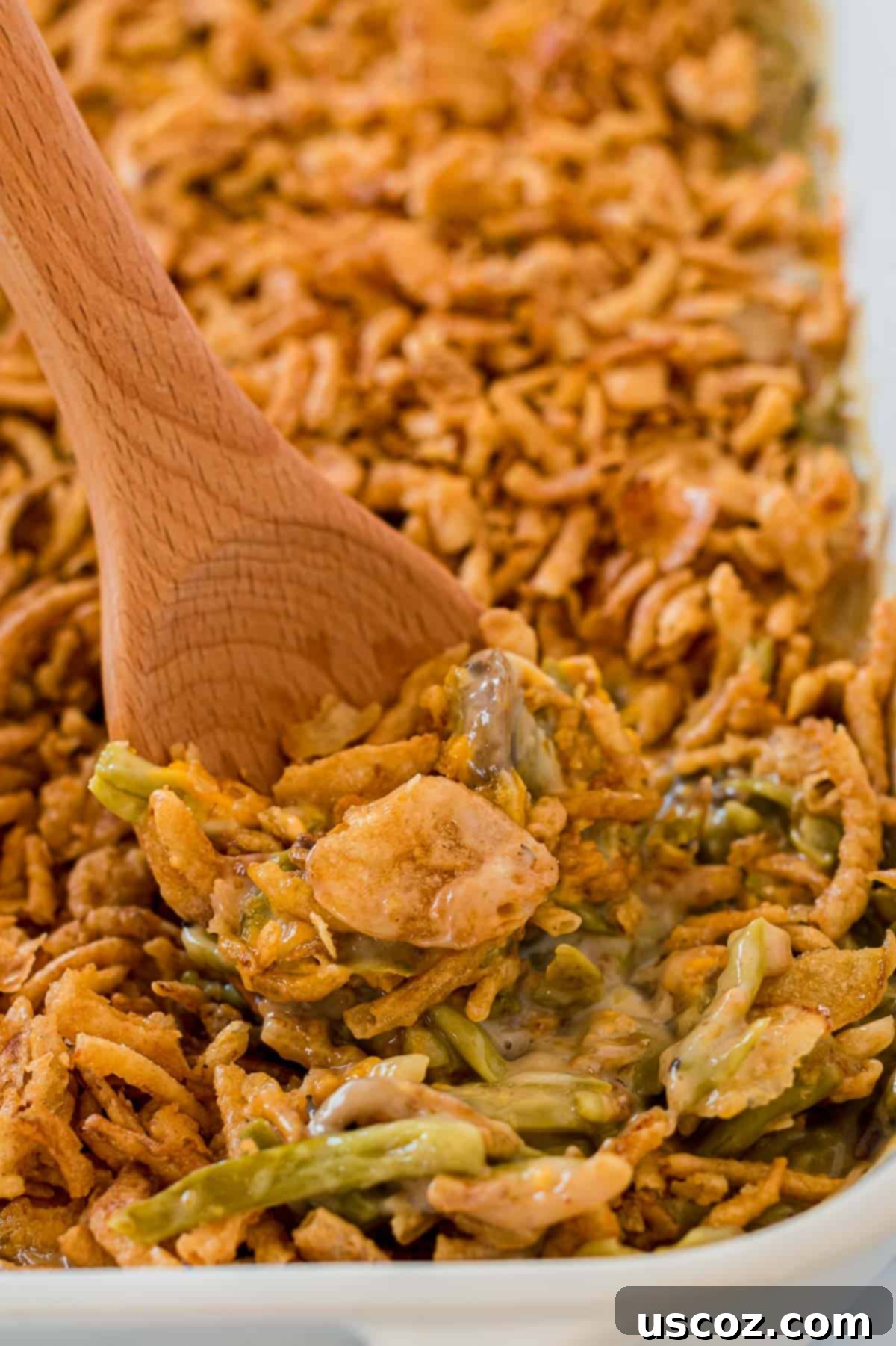 taking a scoop of green bean casserole from the dish