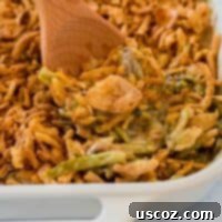 taking a scoop of green bean casserole from the dish