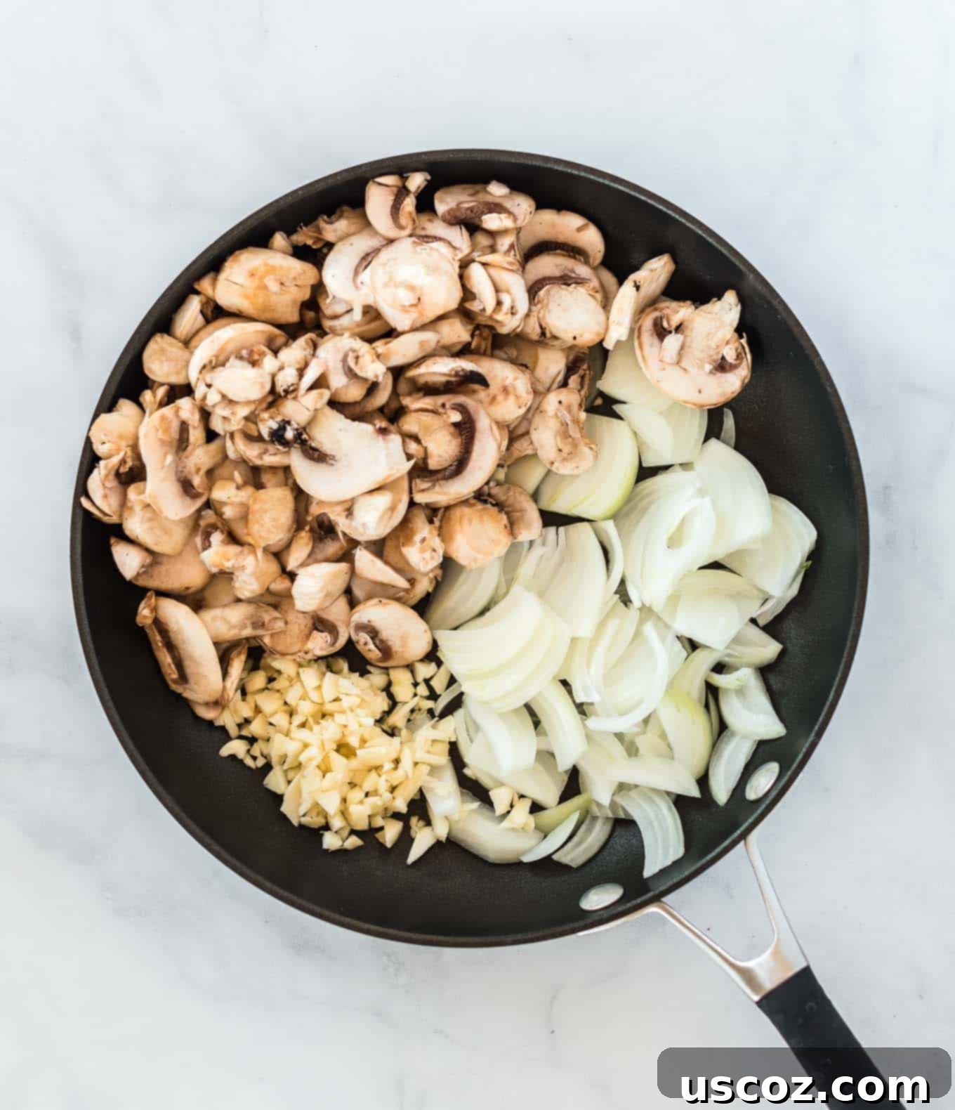 a skillet with mushrooms, minced garlic, and chopped onion in it