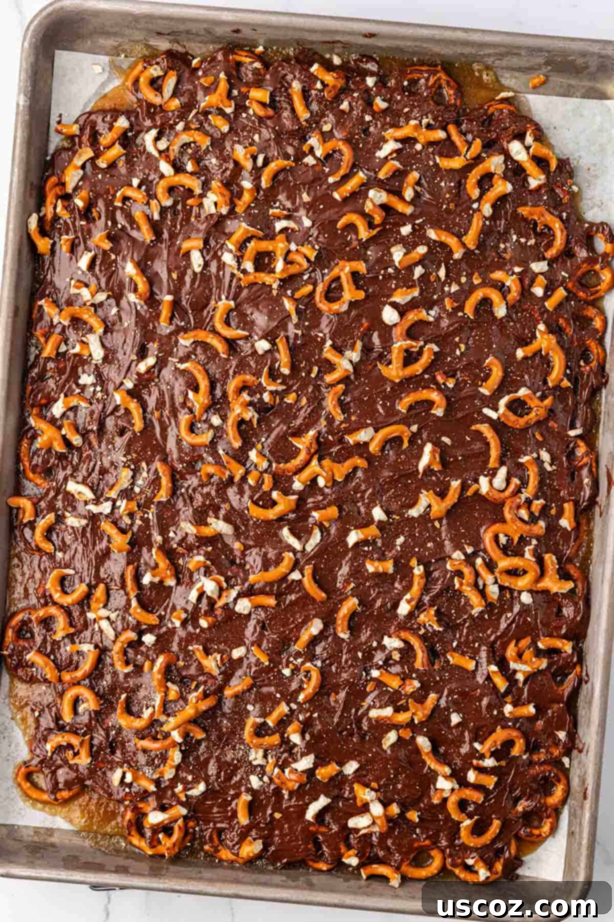 Holiday Pretzel Crunch 17 adding the crushed pretzels to the melted chocolate