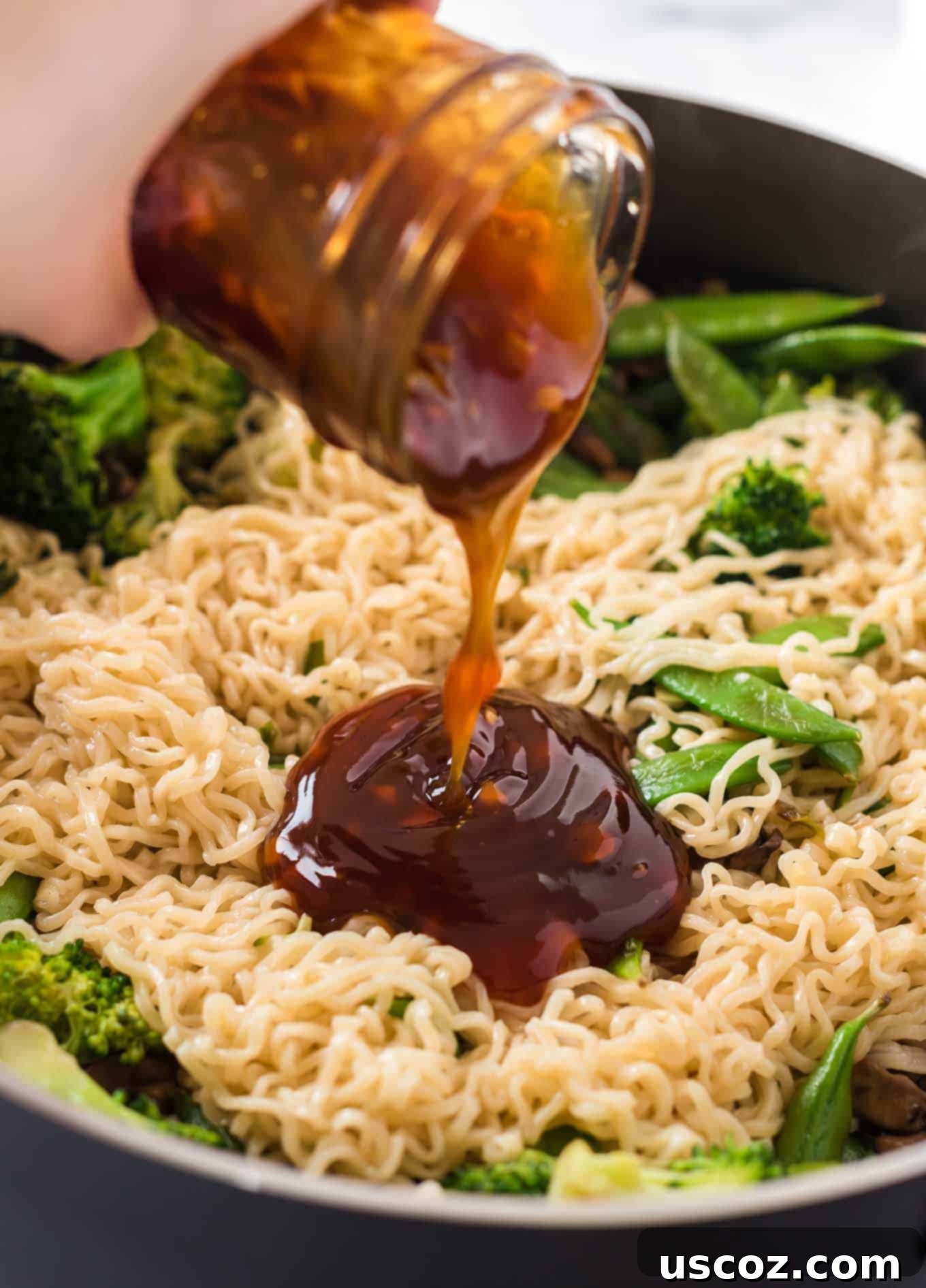 Homemade Teriyaki Sauce 3 Thick, glossy homemade teriyaki sauce being generously poured over a bowl of savory ramen noodles, enhancing their flavor.