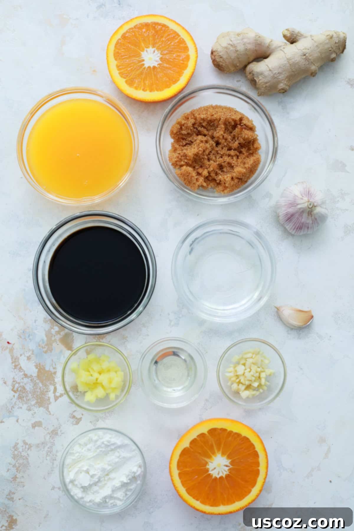Homemade Teriyaki Sauce 4 All the fresh ingredients for homemade teriyaki sauce, including soy sauce, orange juice, brown sugar, rice vinegar, garlic, ginger, corn starch, and cold water, neatly lined up on a wooden surface.