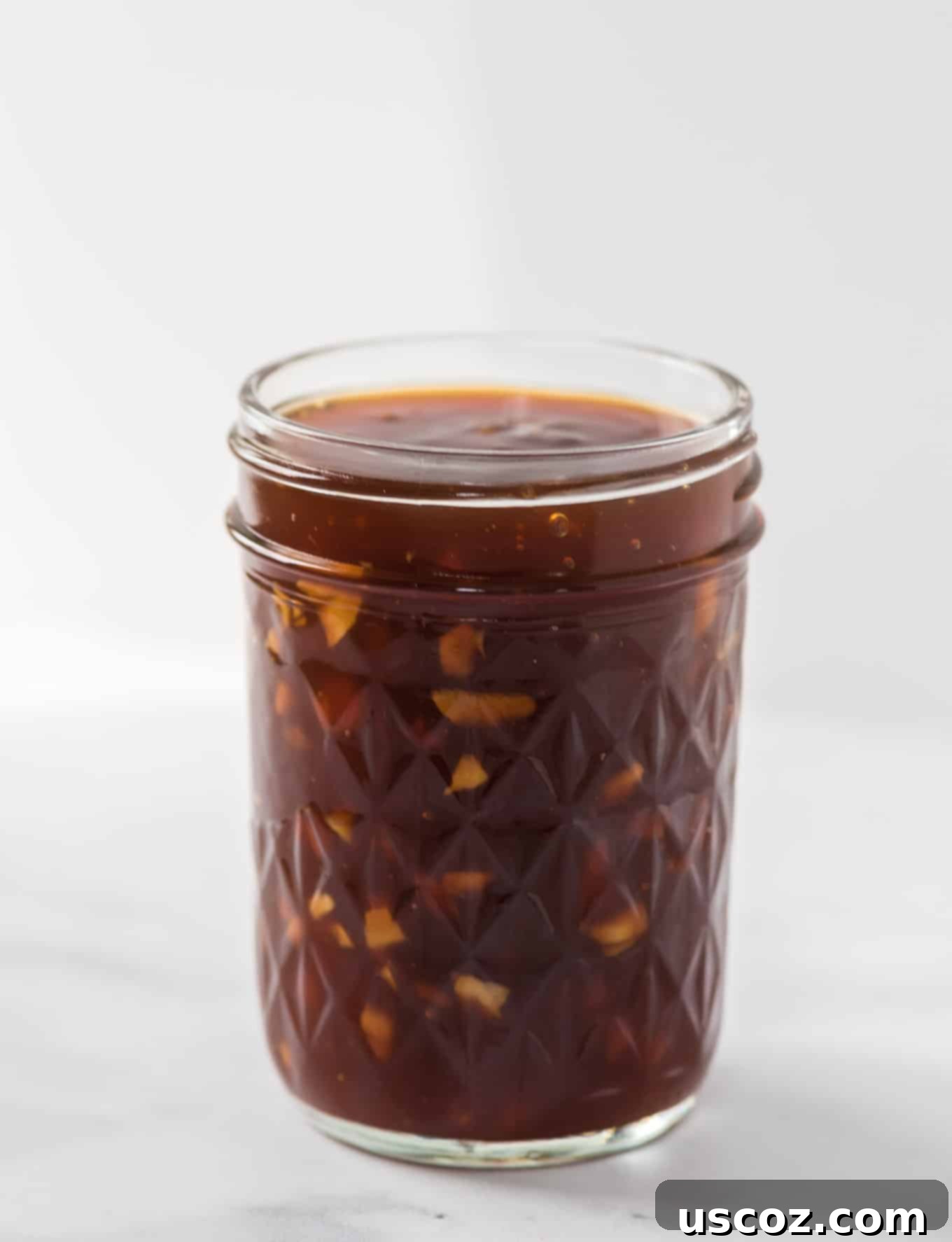 Homemade Teriyaki Sauce 7 A mason jar filled with freshly made, thick homemade teriyaki sauce, garnished with a sprig of fresh herbs.