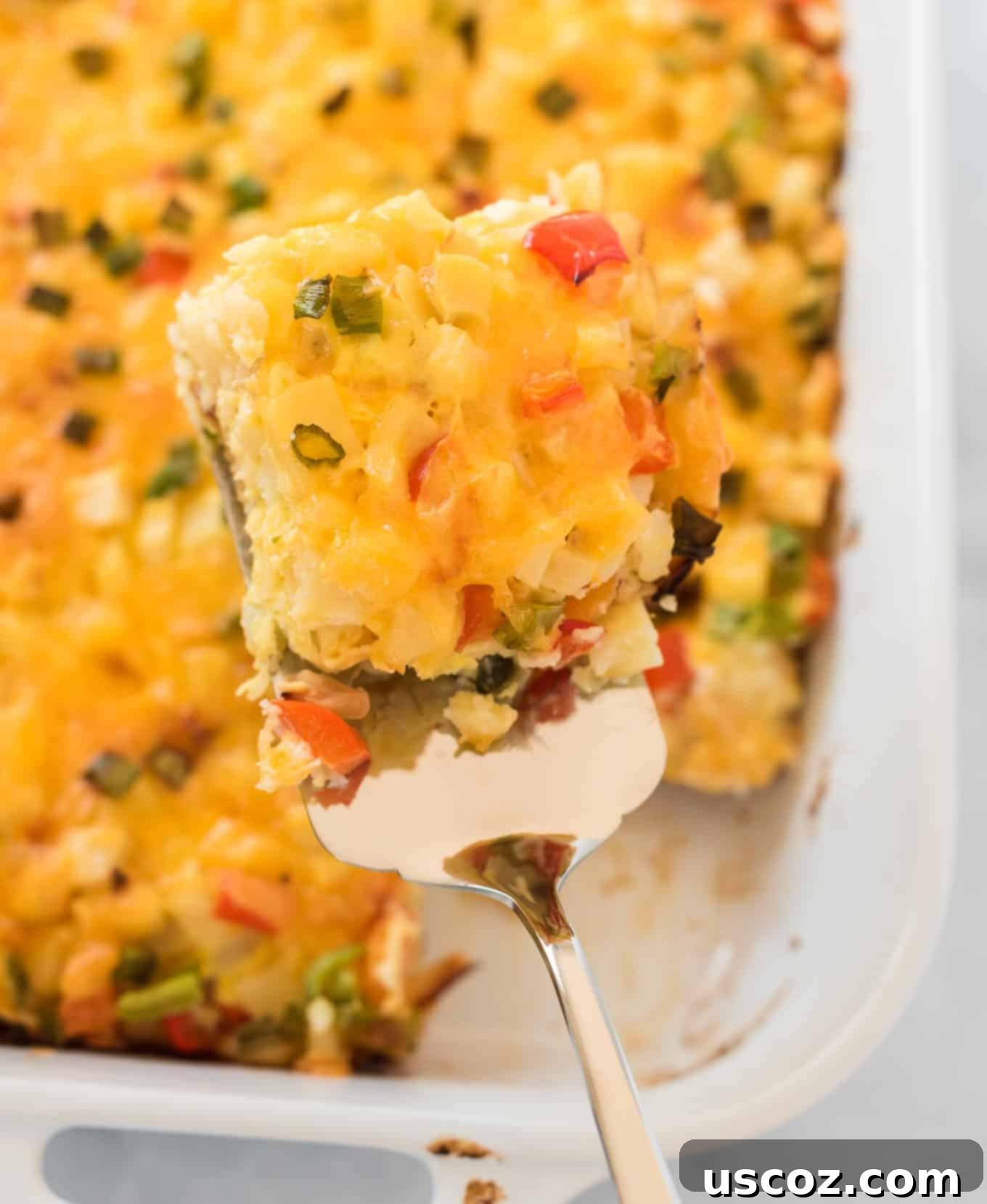 Golden Hash Brown Egg Bake 11 a spatula holding a square of casserole over the dish
