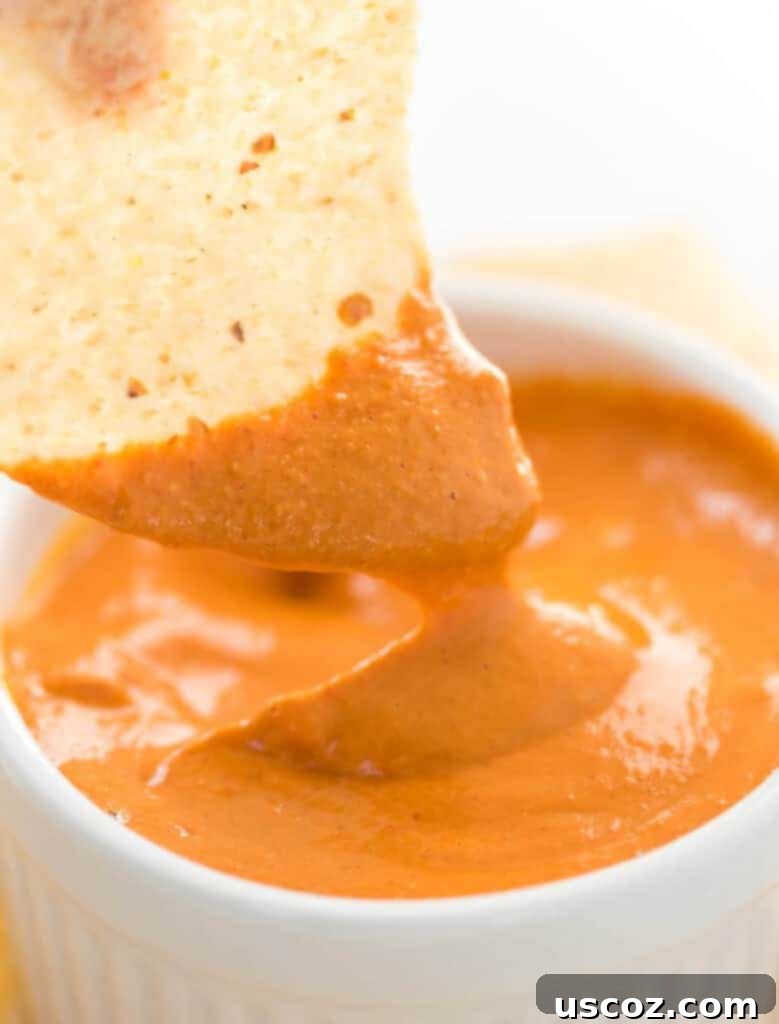 Creamy Plant-Based Queso 3 chip dipped in vegan queso
