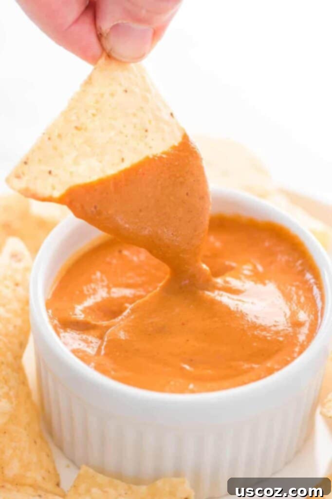 Creamy Plant-Based Queso 7 chip dipped in vegan queso