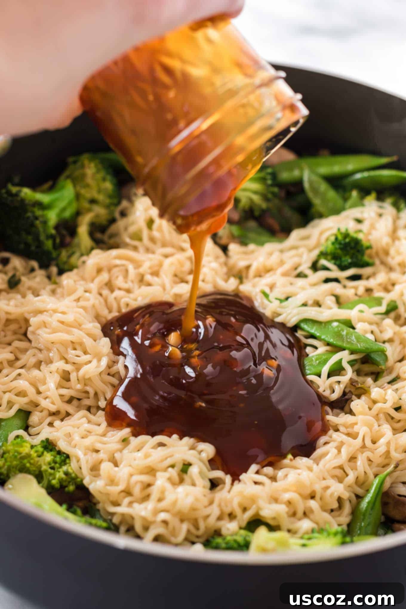 Sweet & Savory Teriyaki Noodles 5 teriyaki sauce being poured onto a stir fry