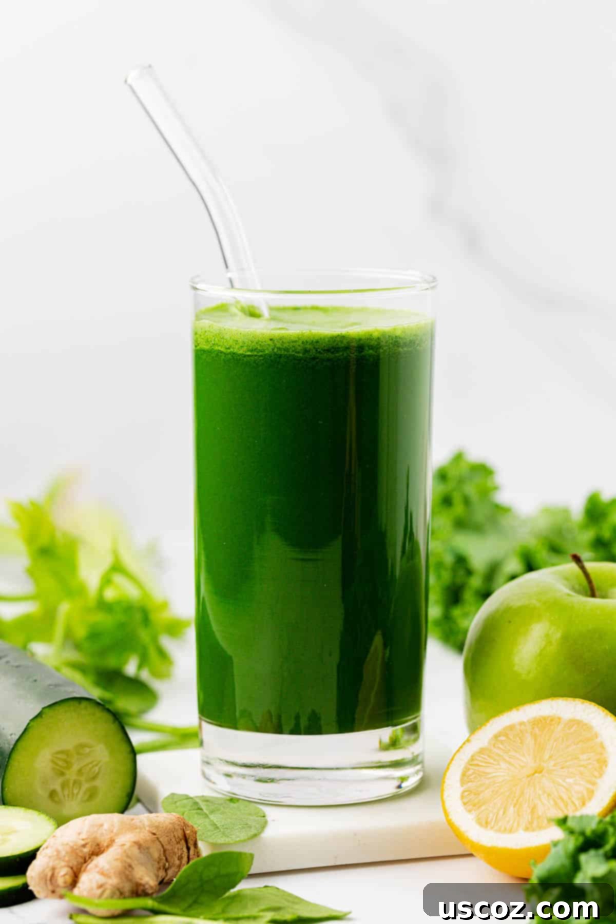 Your Daily Green Boost 14 green juice in a glass with a straw