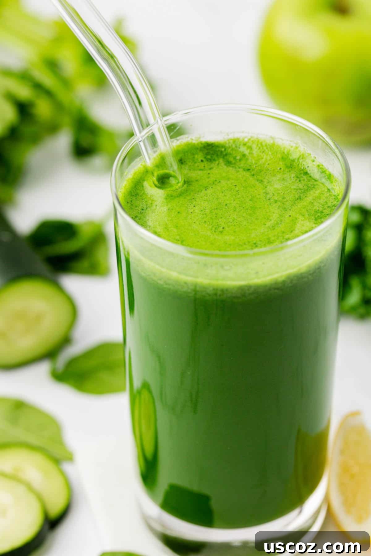 Your Daily Green Boost 8 green juice in a glass with a straw