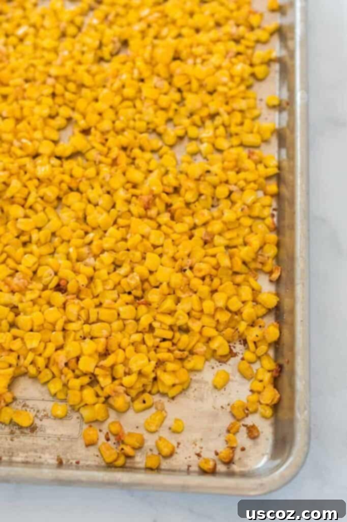 Crispy Roasted Frozen Corn 2 Roasted corn on a baking sheet, golden brown with parmesan cheese